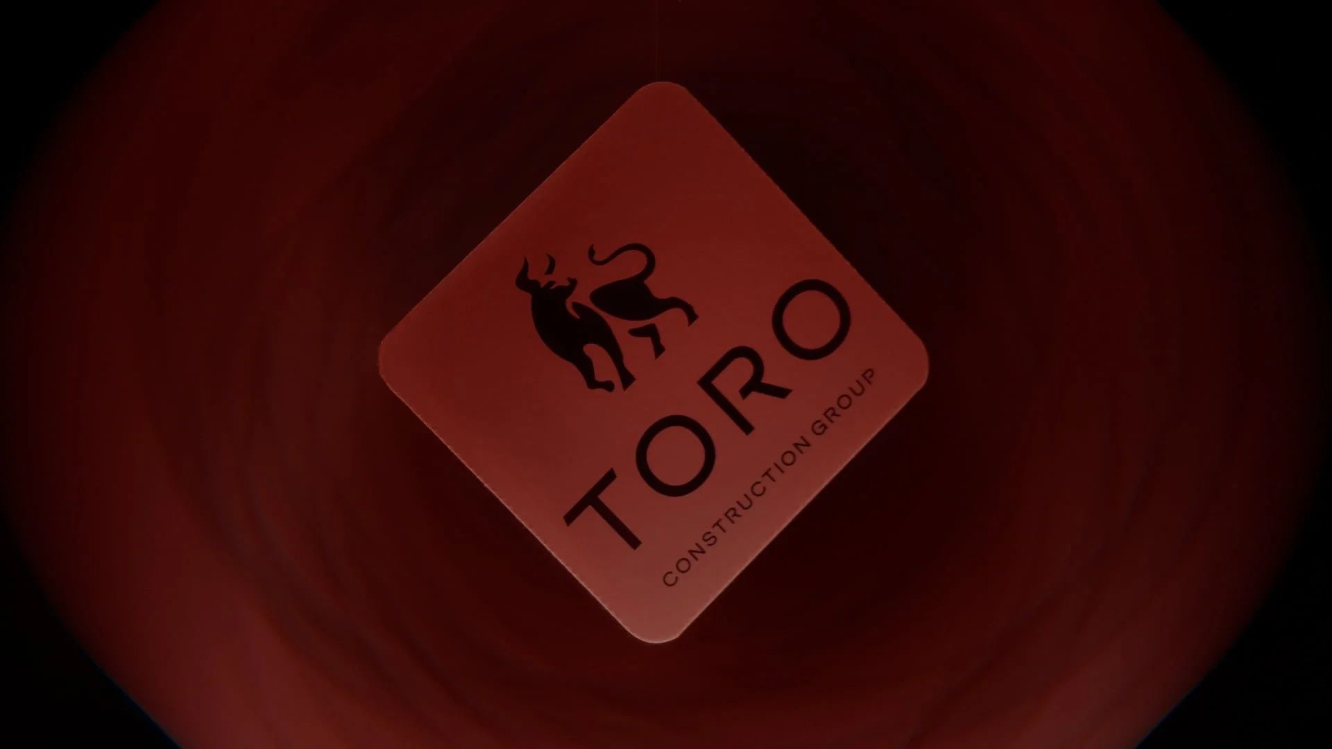 A red warning sign with a black ox symbol and the text "TORO Construction Group."