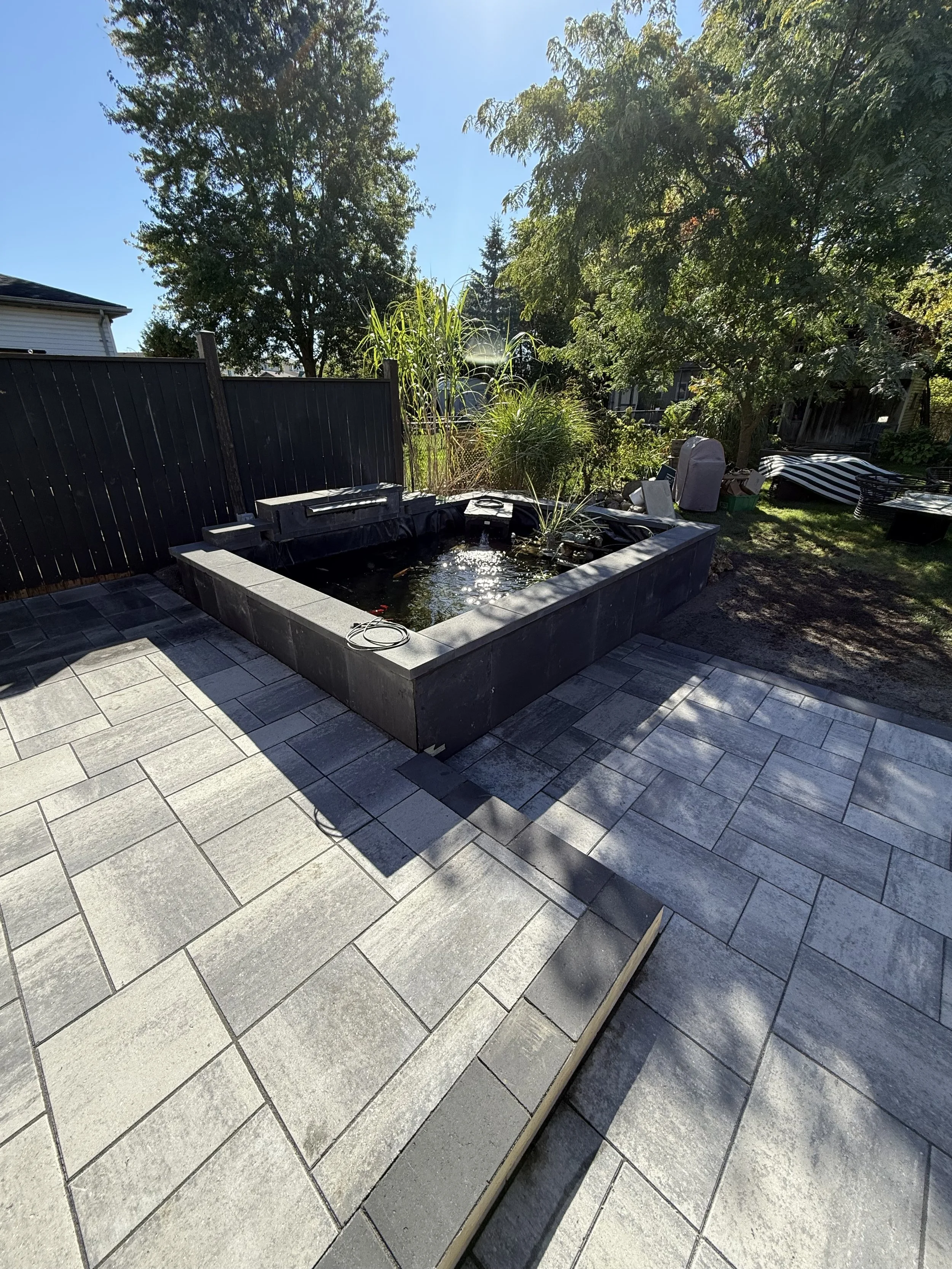 Backyard with a new look! It contains a brand new pond with coping and facing stone, it also includes a two tiered patio, perfect for entertaining