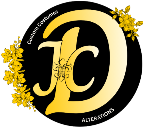 Official logo letters JC centered by the Letter D in large gold Cursive. Fleur de Les outlined in the center of letters. Flowers frame the edge of the black circle with the words custom costumes and alterations in white