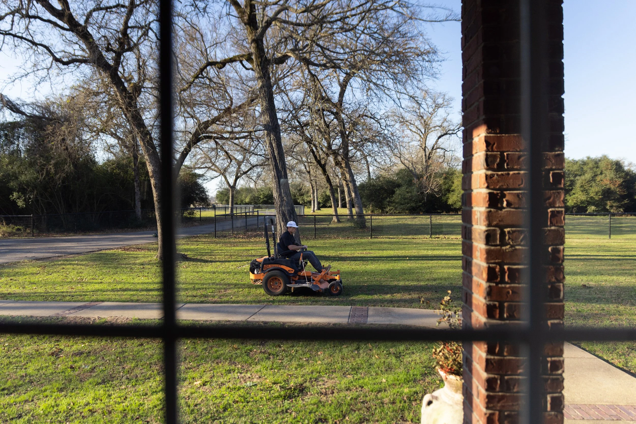 Professional lawn care service maintaining a residential yard in Bryan, TX.