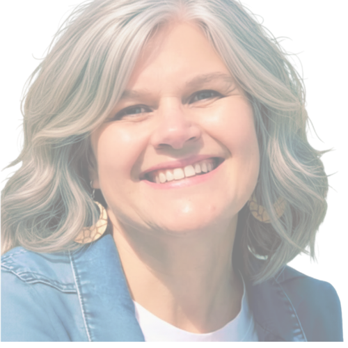 Close-up of a smiling woman with gray hair, wearing earrings and a blue denim jacket.