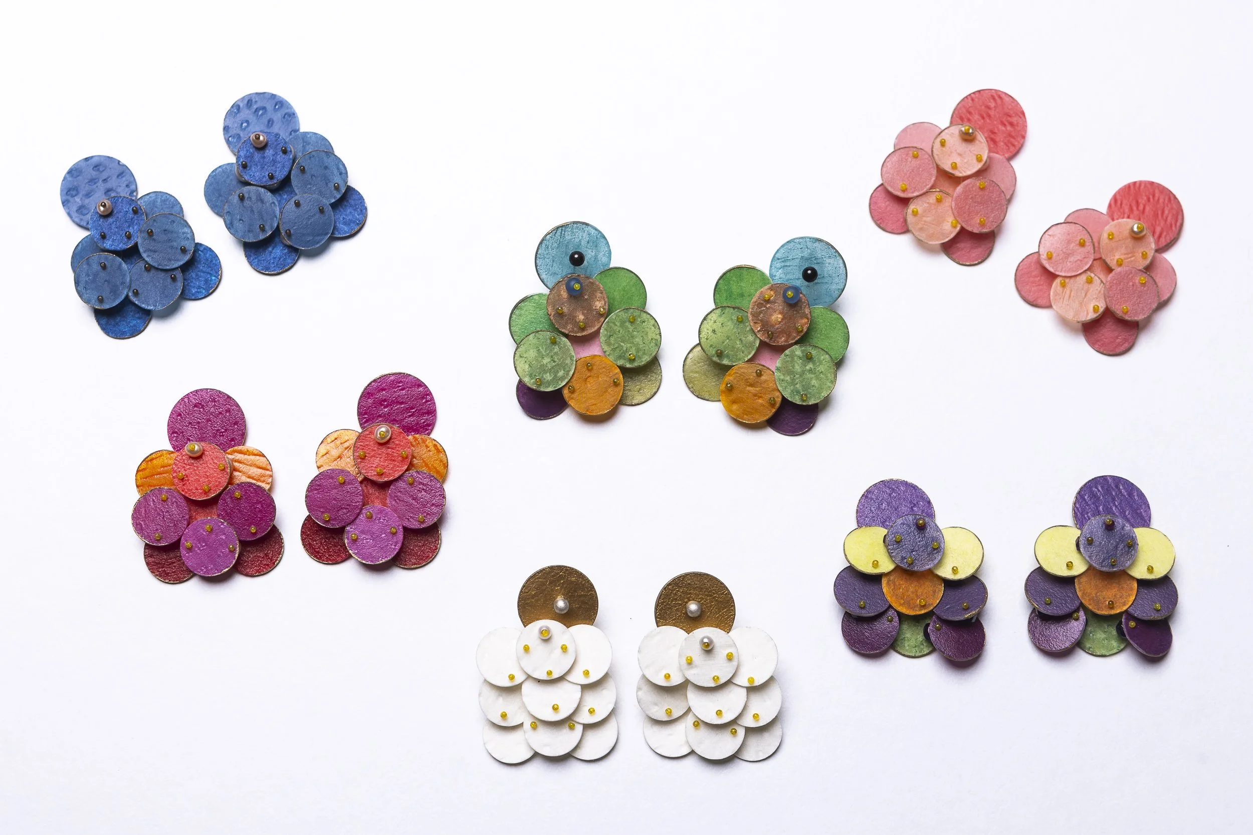 Bunte Ohrringe in verschiedenen Farben auf weißem Hintergrund.