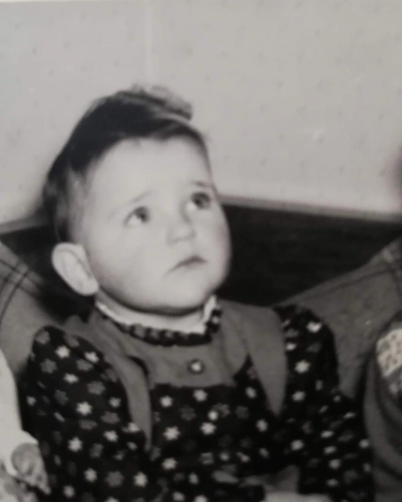 Schwarz-Weiß-Fotografie der jungen Hilde Janich mit dunklen Haaren und gestreiftem Pullover.
