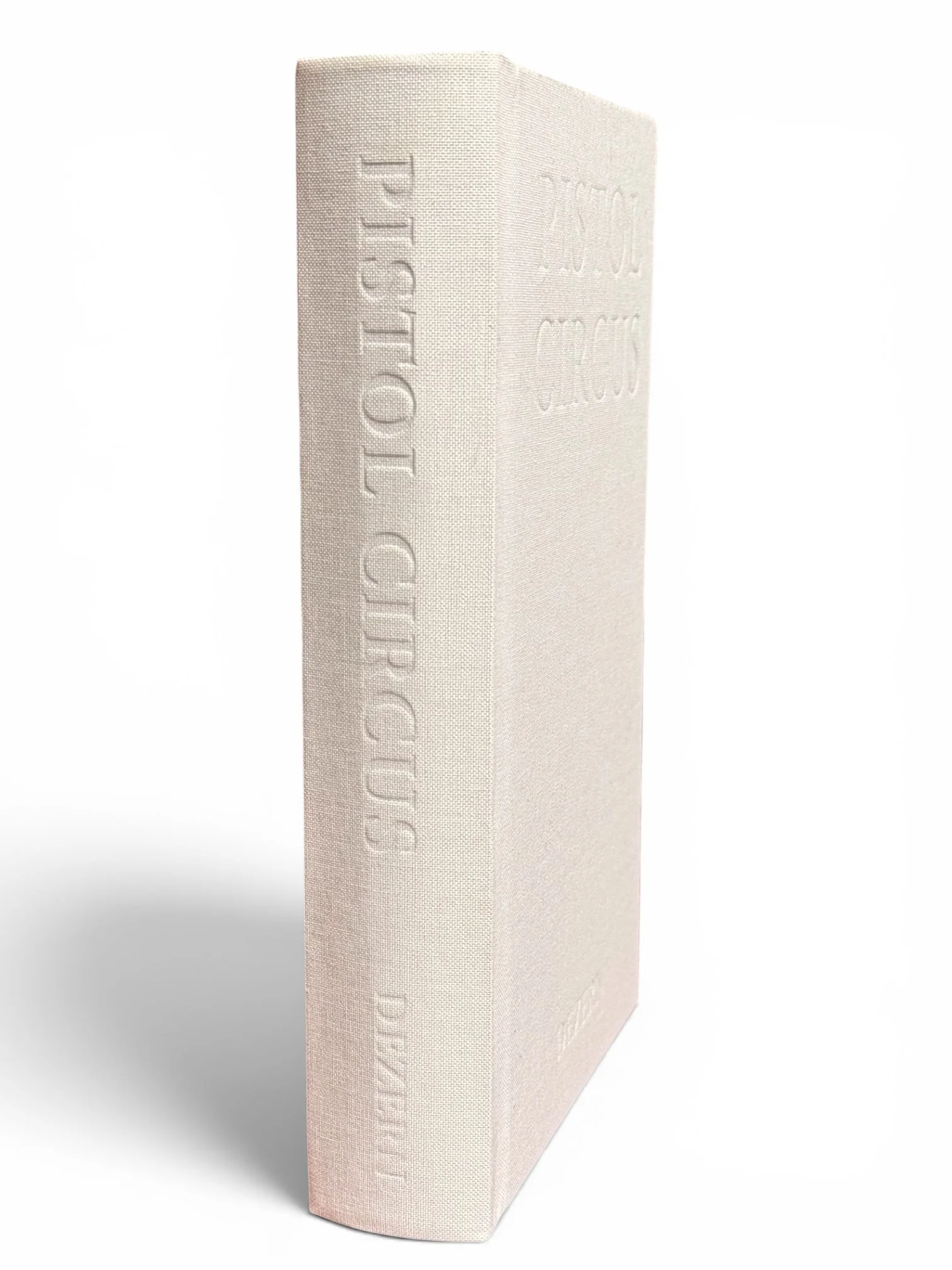 A close-up of an off-white hardcover book standing upright with embossed text on the spine, against a white background with a subtle shadow cast by the book.