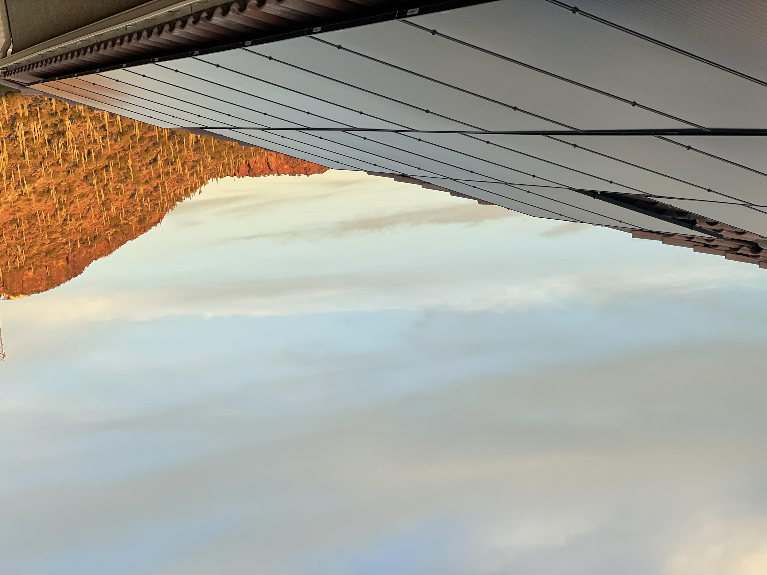 Photography of a modern building's roof structure with a mountain in the background.