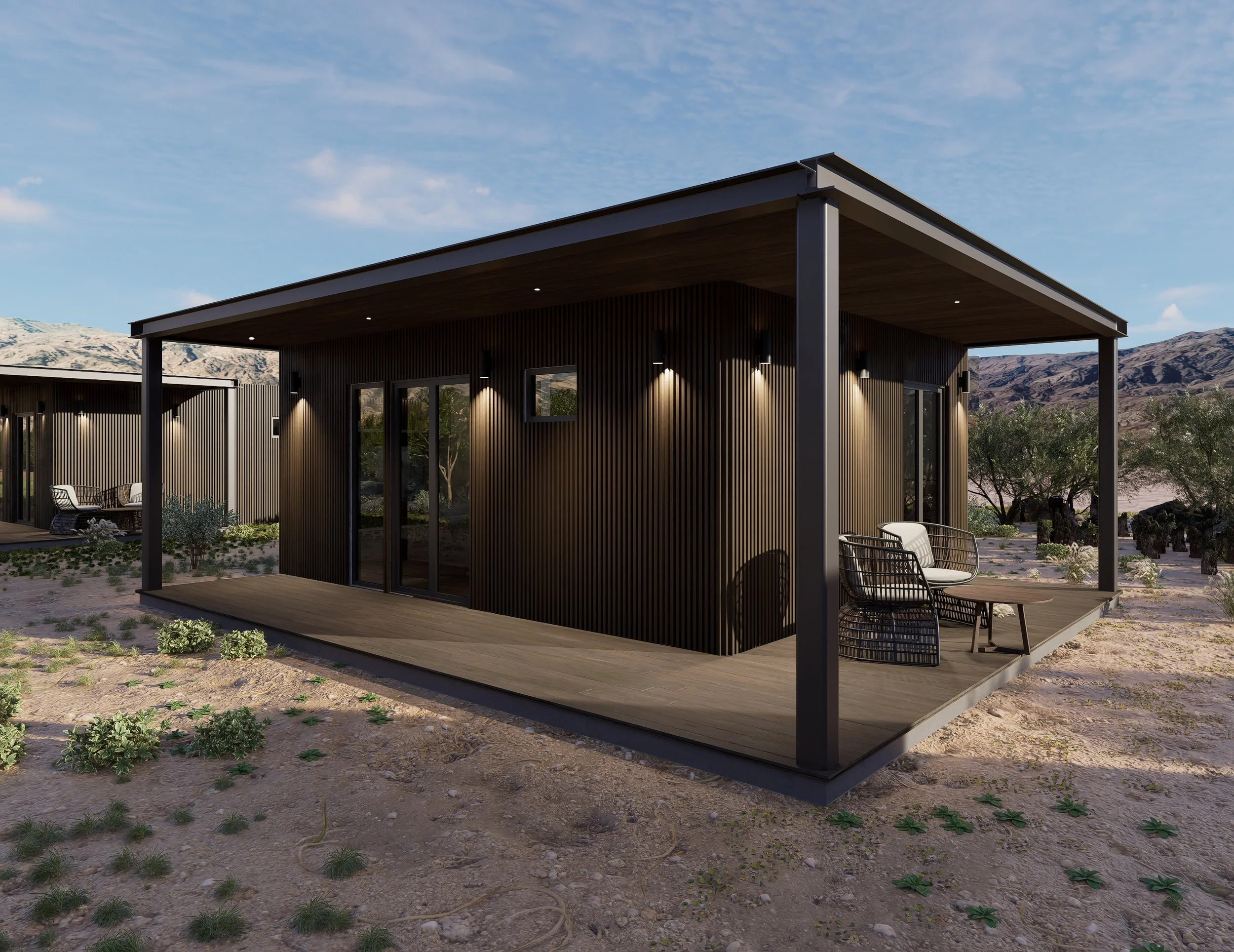 Modern black house with wooden exterior and a covered patio, set in a desert landscape with mountains in the background.