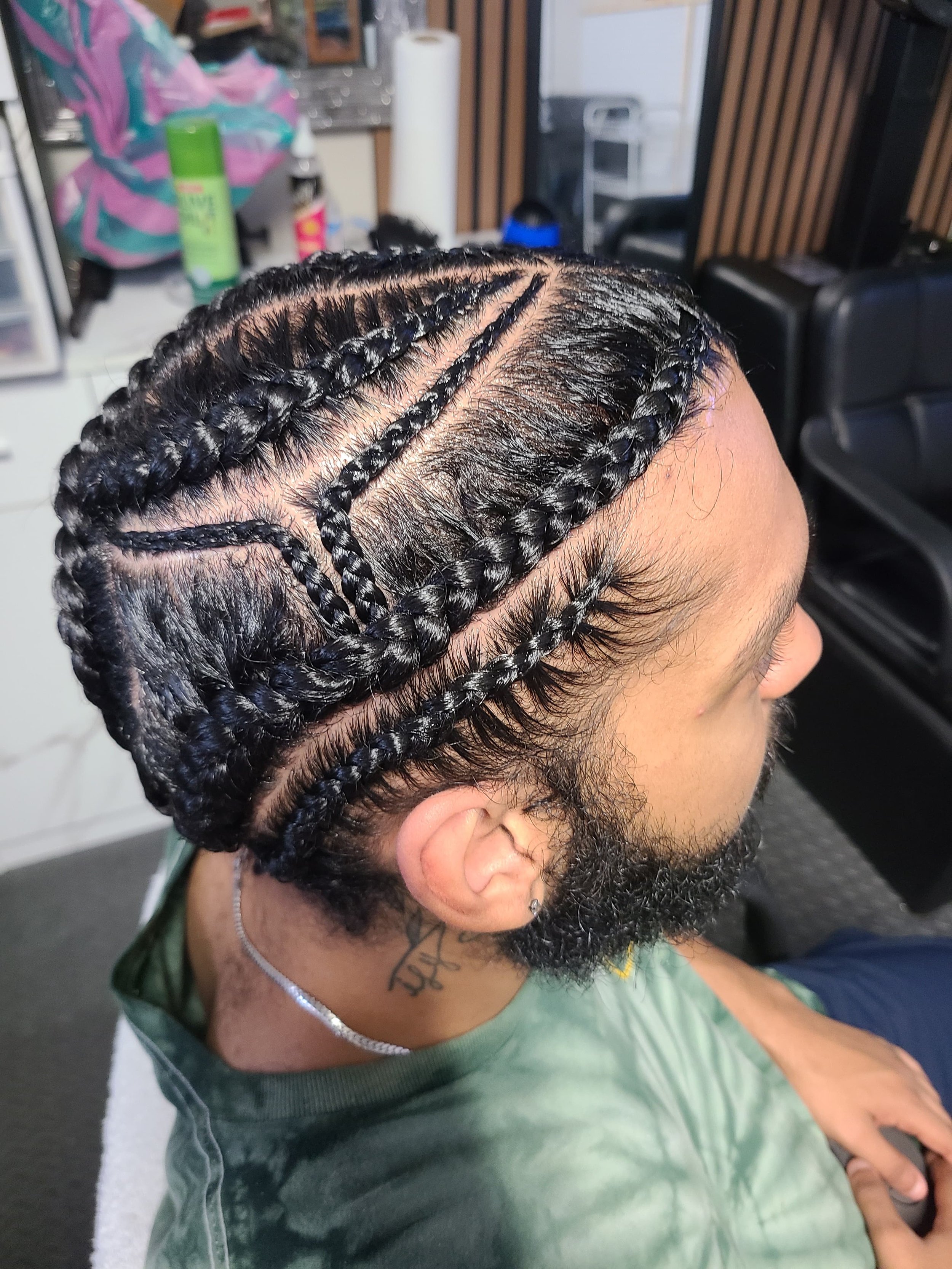 Close-up of a man with his hair styled in neat, intricate braids.
