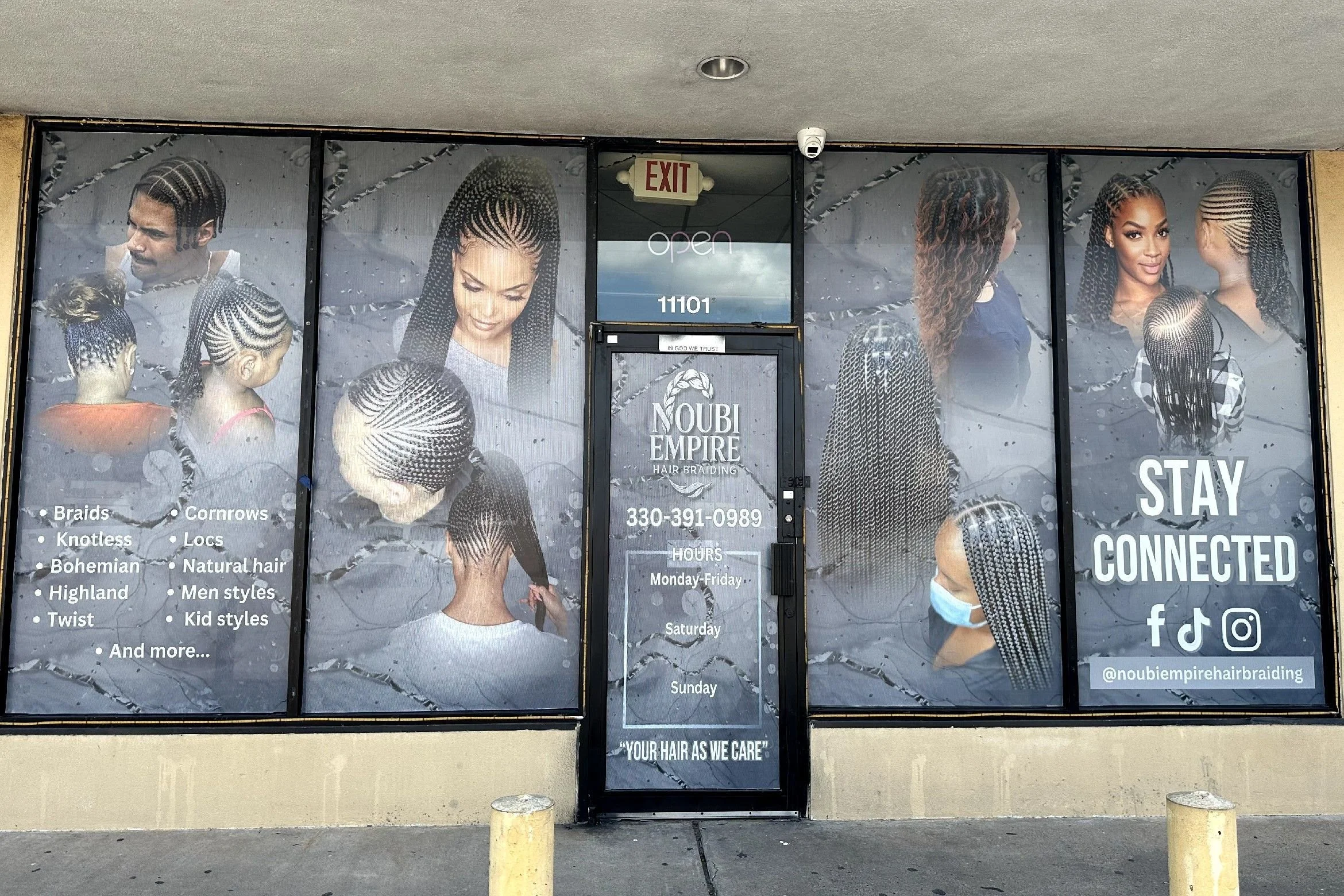 storefront window advertising hair braiding services with images of women with various braided hairstyles, a list of braid styles including cornrows and natural hair, and social media icons for Facebook, TikTok, and Instagram.
