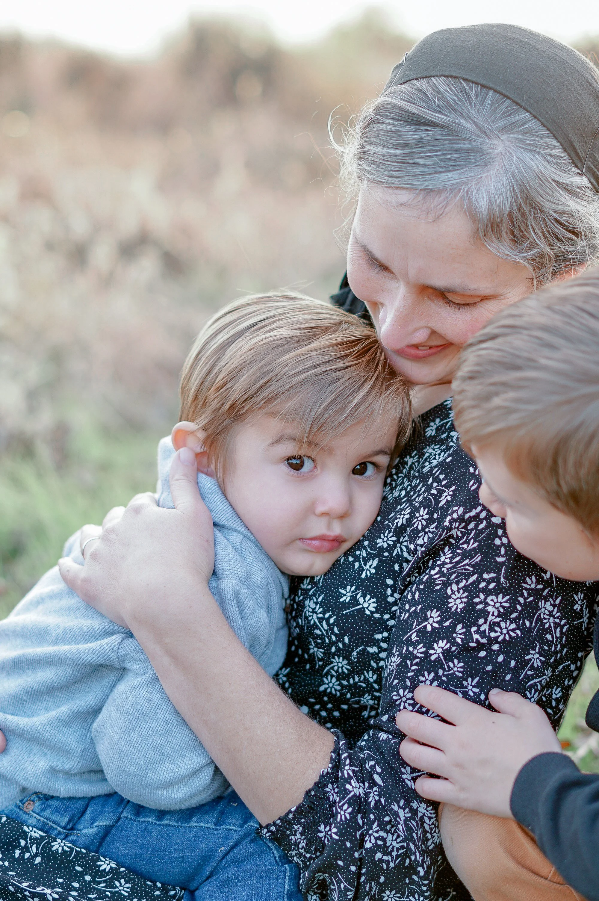 A mother gently holding her son during a family photo session at Pennypack on the Delaware, in Philadelphia