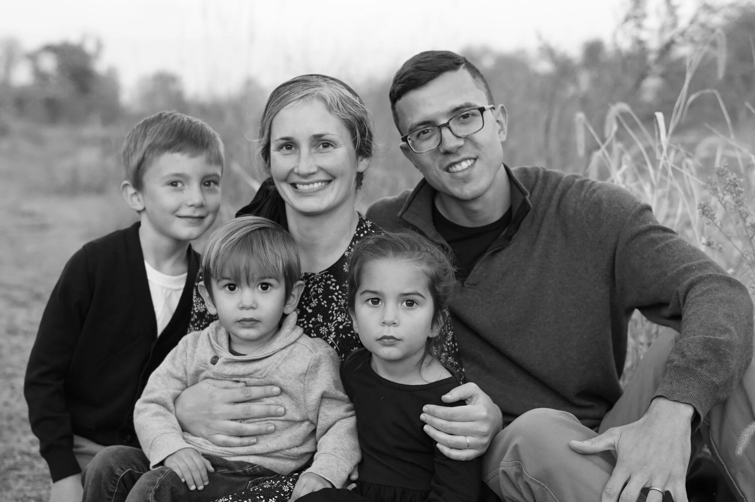 A family with three children smiling as they get their photo taken at the Pennypack on the Delaware Park in Philadelphia.