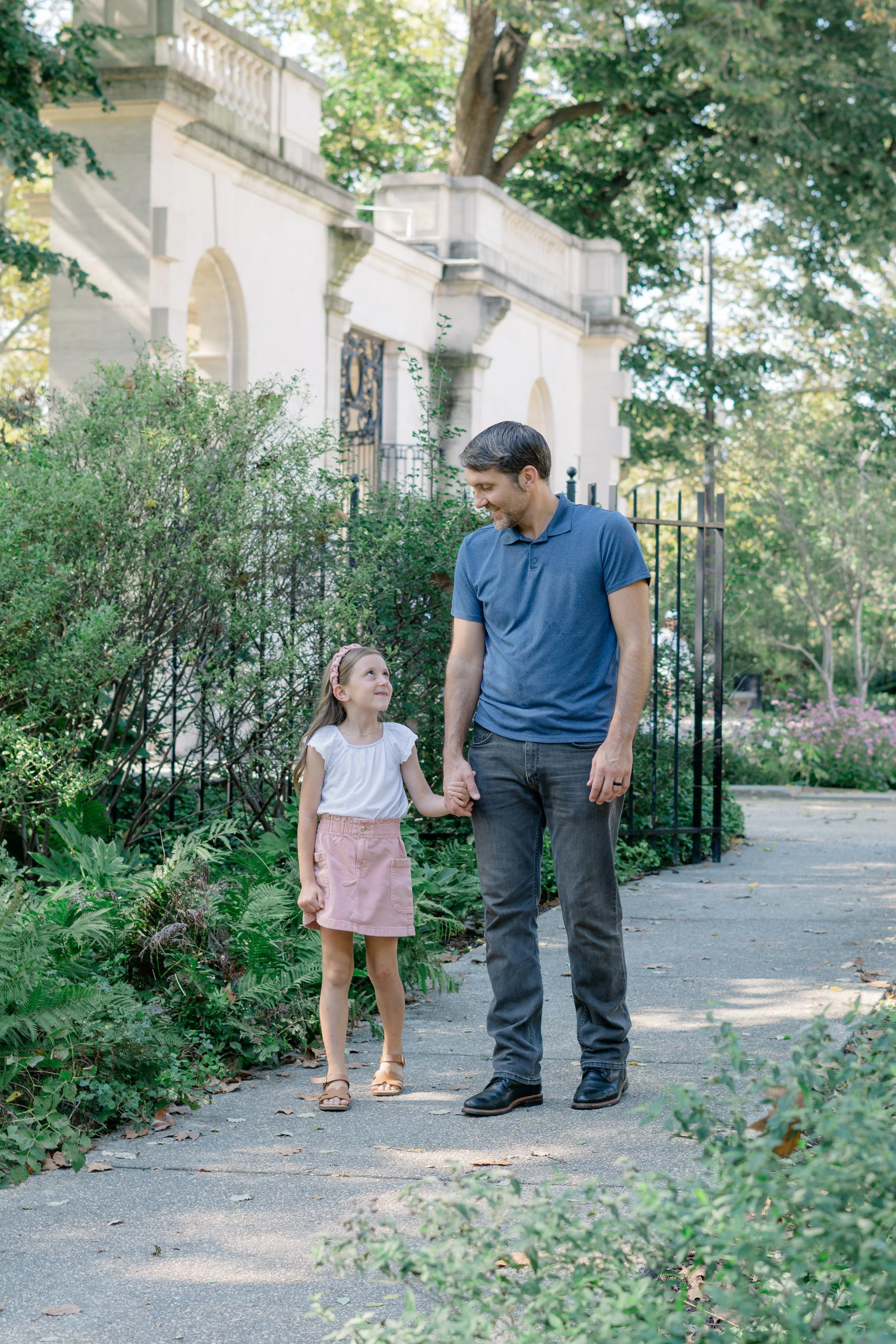 Father and daughter holding hands at a family portrait session at Rodin Museum, Philadelphia. 