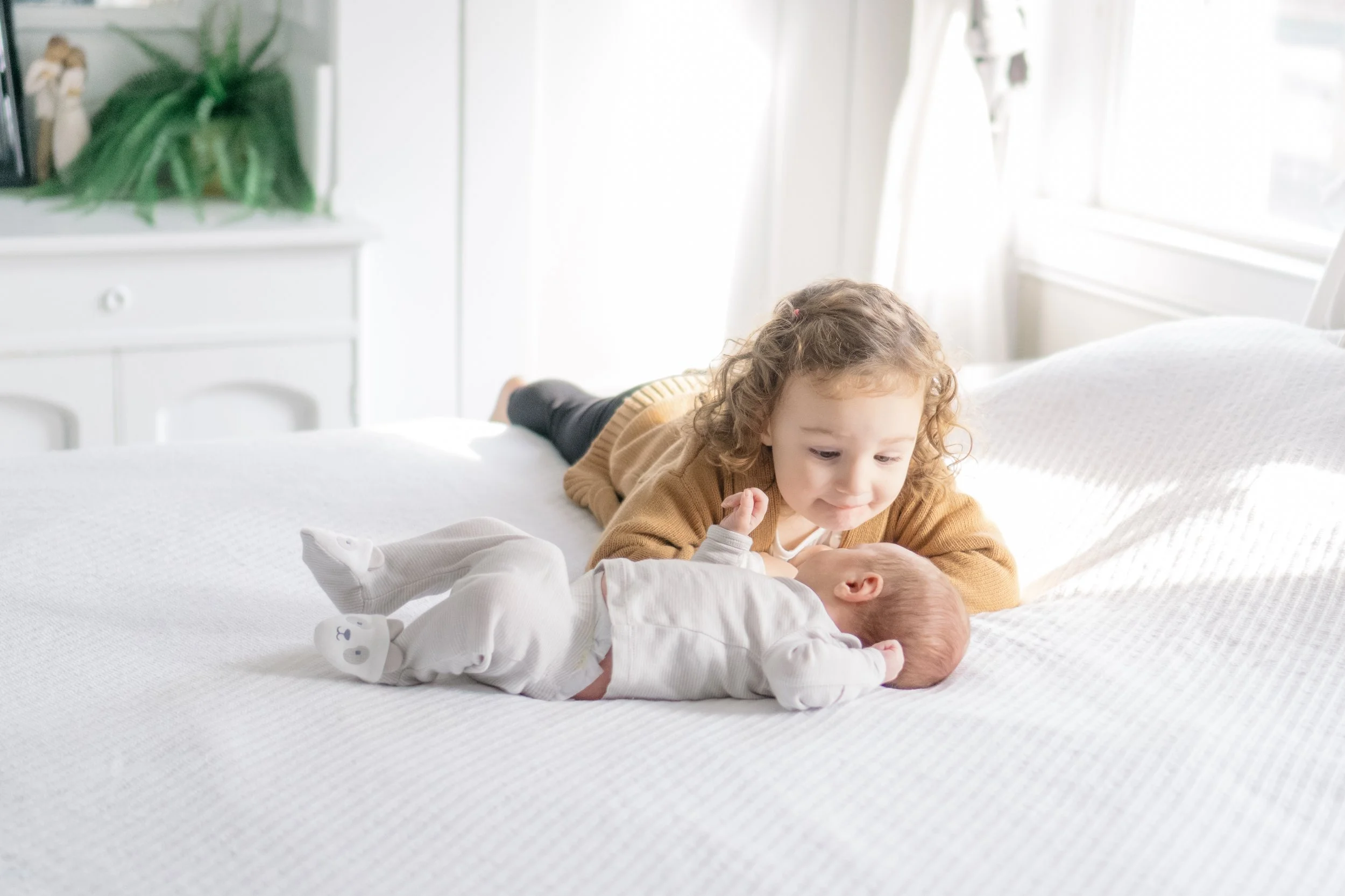 In-door newborn session with plenty of warm lighting, and sibling love.