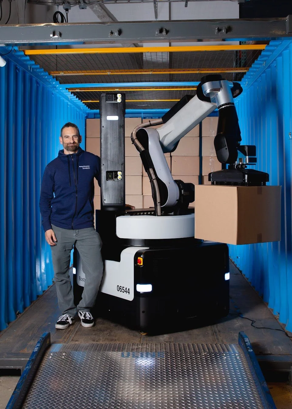 Kevin Blankespoor standing next to a Stretch Robot inside a shipping container