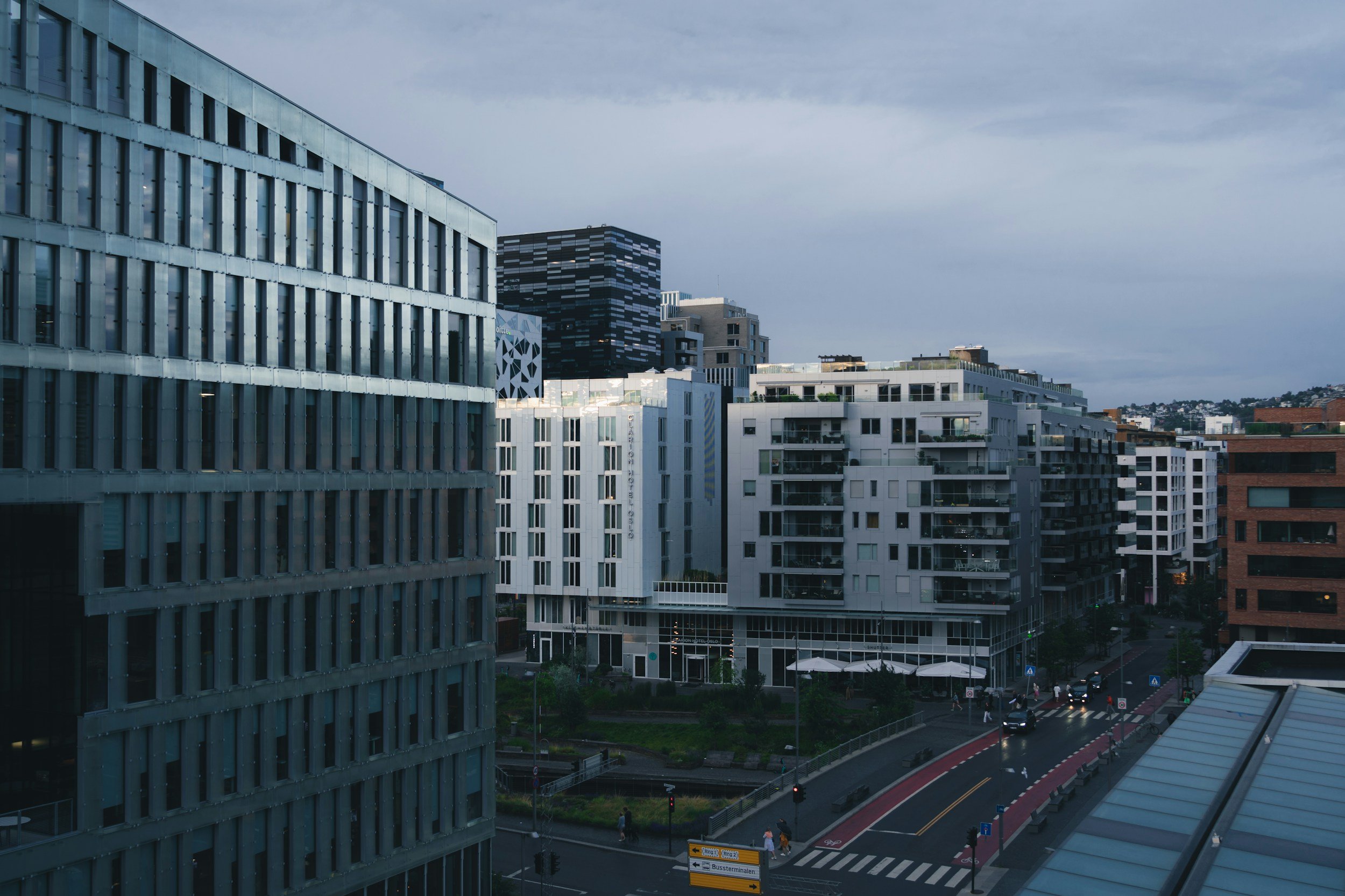 Moderne næringsbygg og leilighetskompleks i bymiljø.