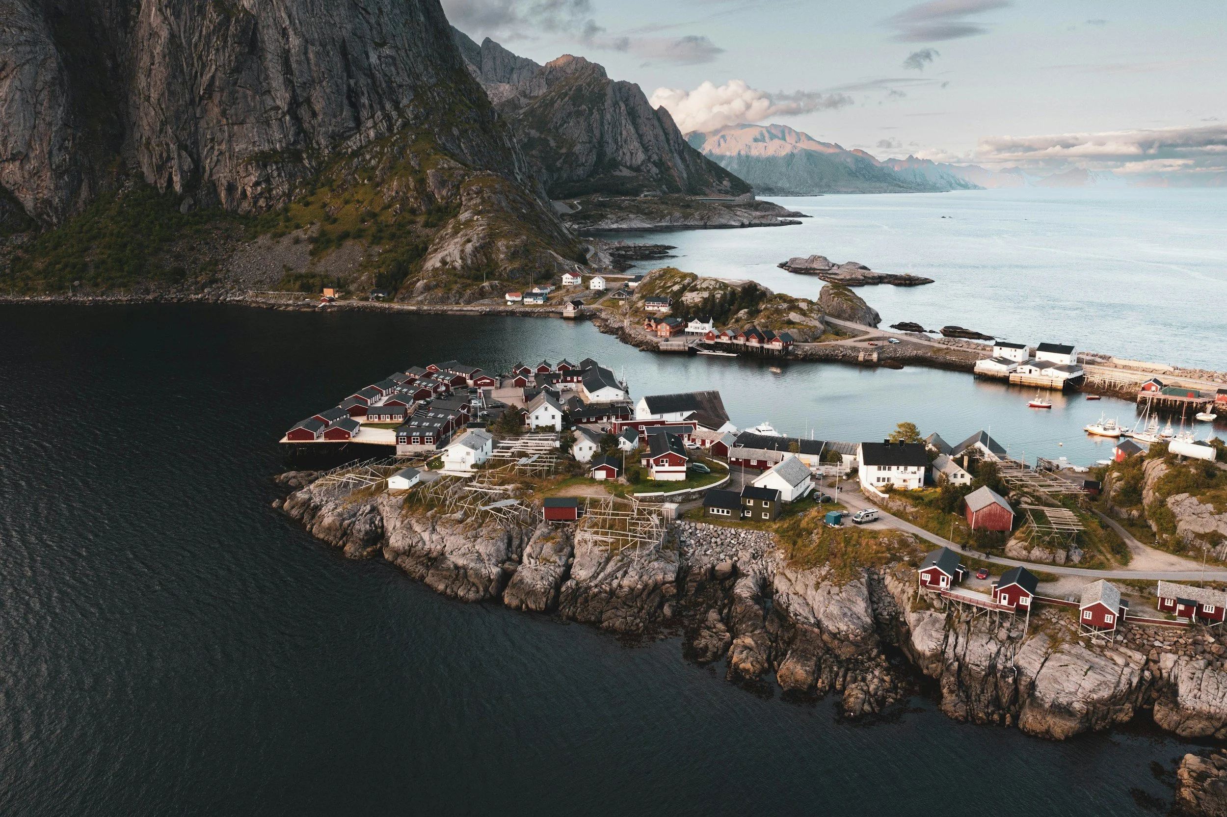 Kystsamfunn med boliger og brygger sett fra luften.