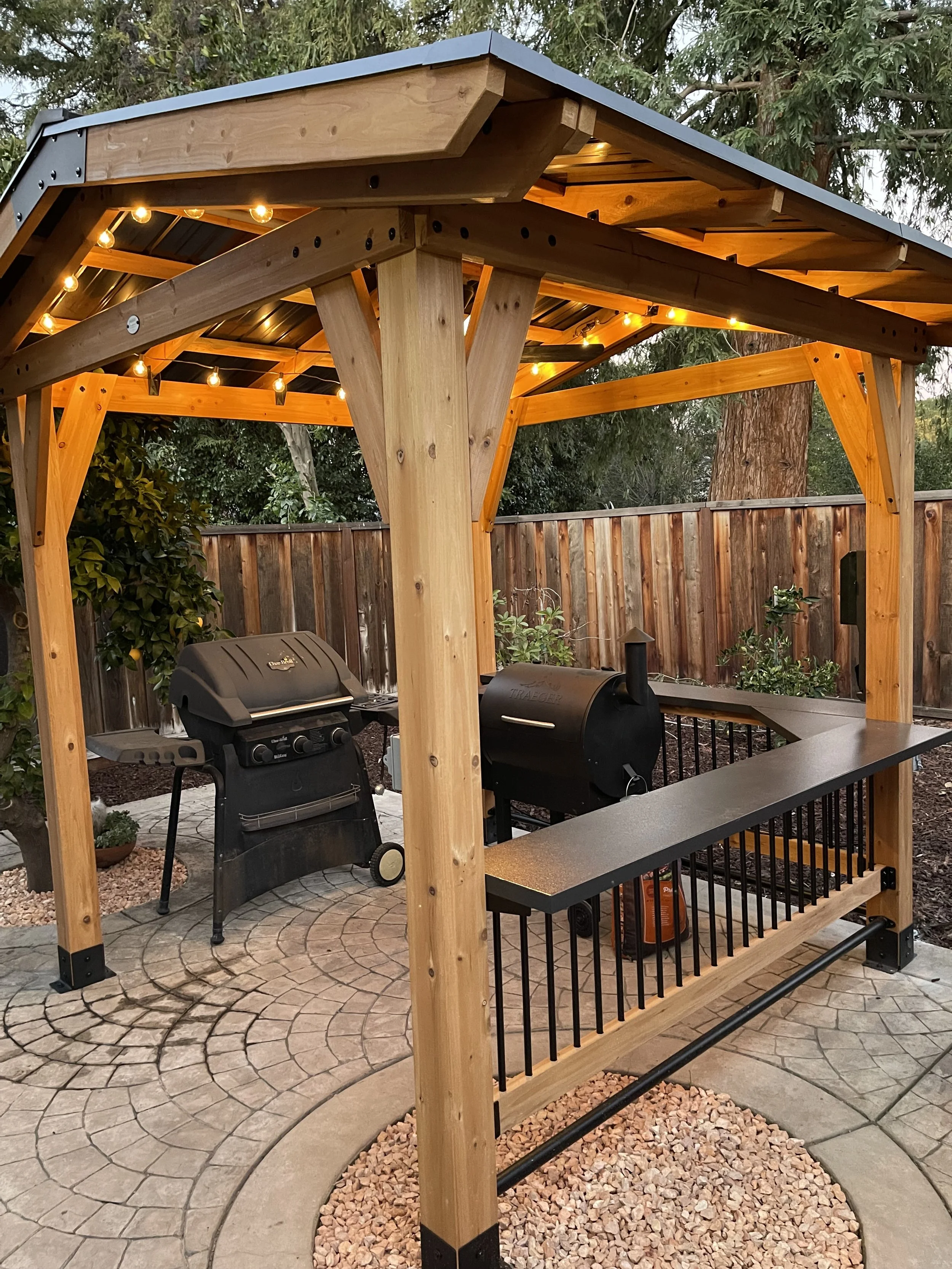 Custom-built outdoor pavilion featuring integrated lighting, detailed wood craftsmanship, and a built-in bar area. Designed as a warm, functional extension of the home for year-round living. 