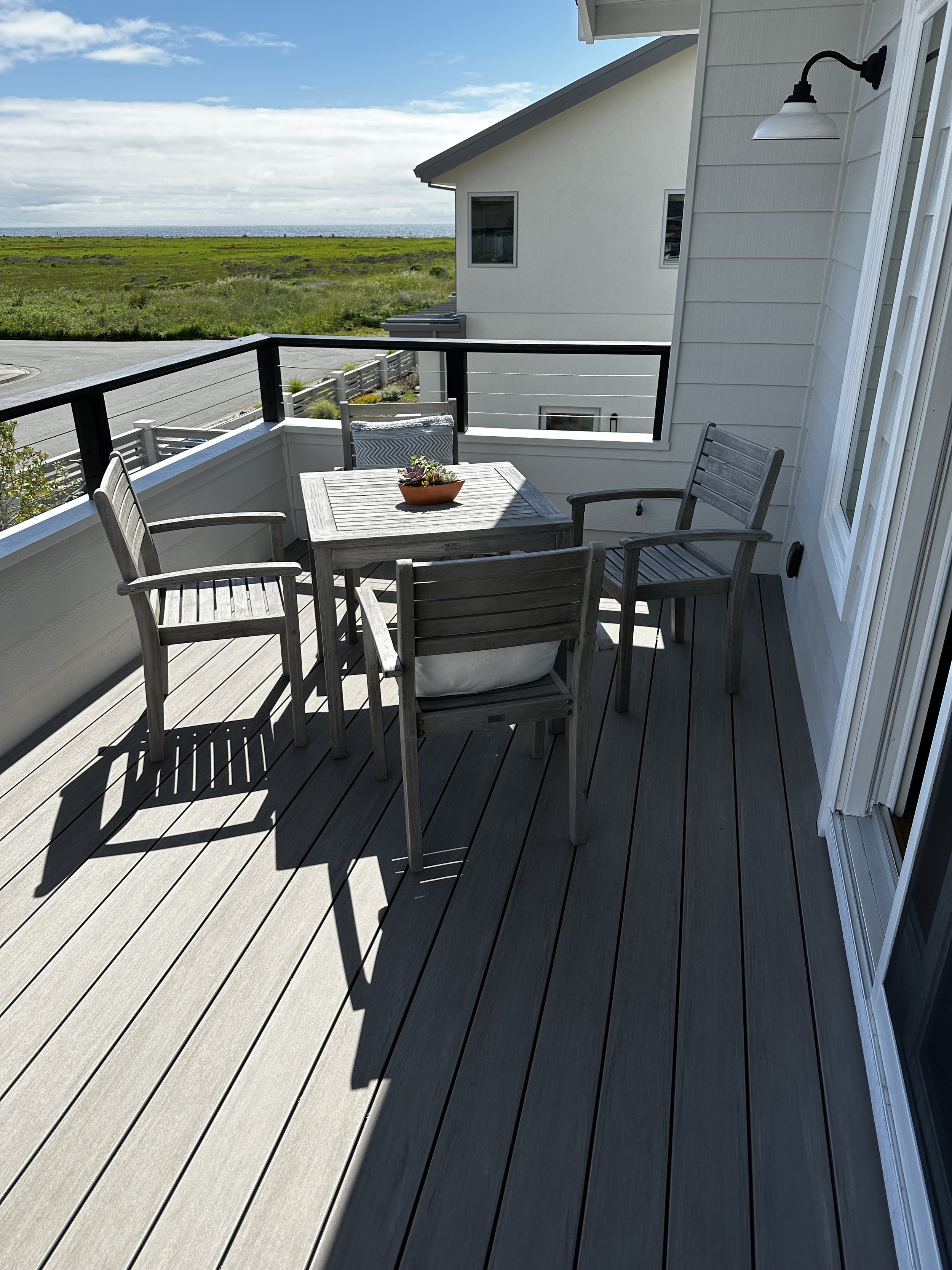 Elevated deck with modern railing designed for outdoor dining and everyday use while offering long-lasting durability and minimal upkeep. 