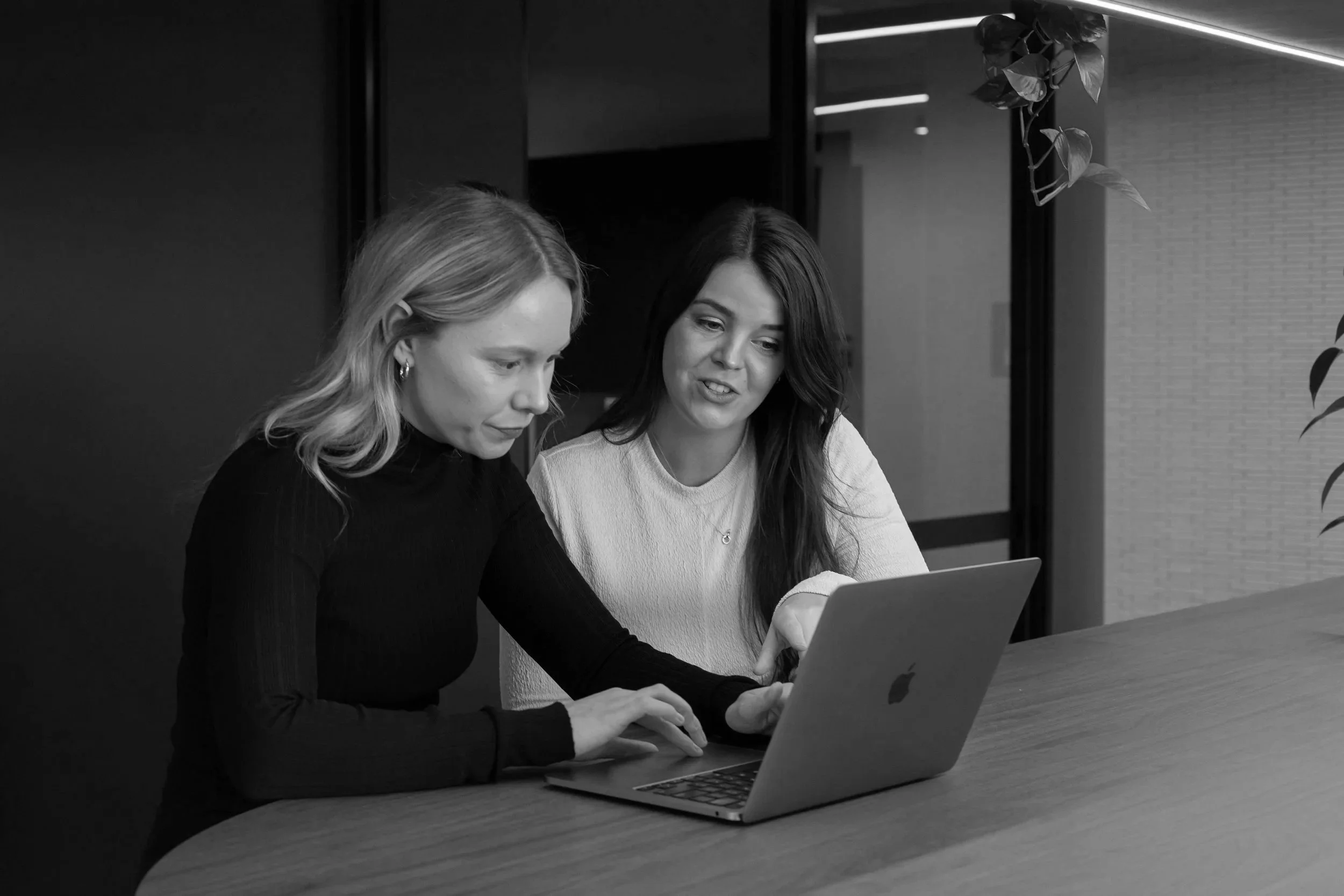 Susanna and Hannah sitting at computer working in Oliver Grace office