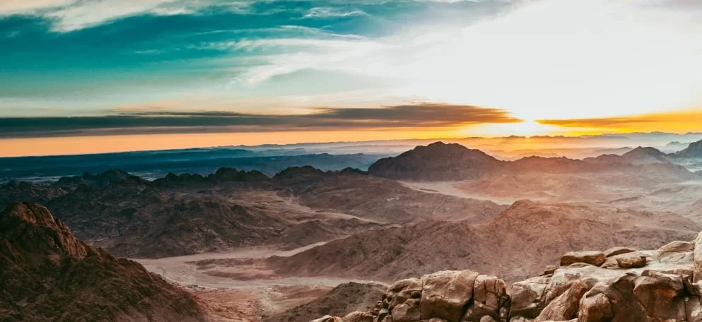 The Sinai Mountains in Egypt with the visible sun low in the sky.