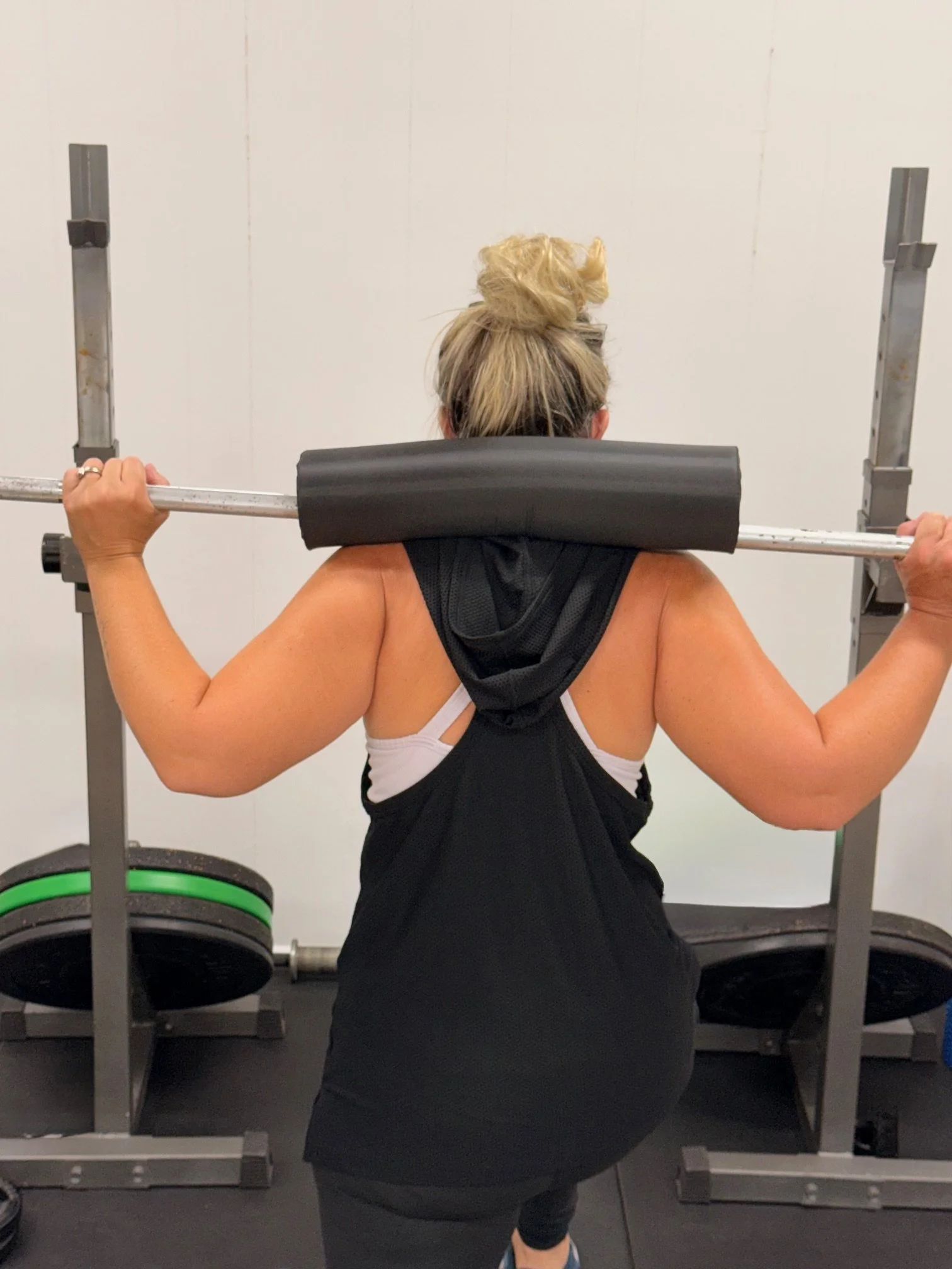 Woman lifting a barbell in gym.