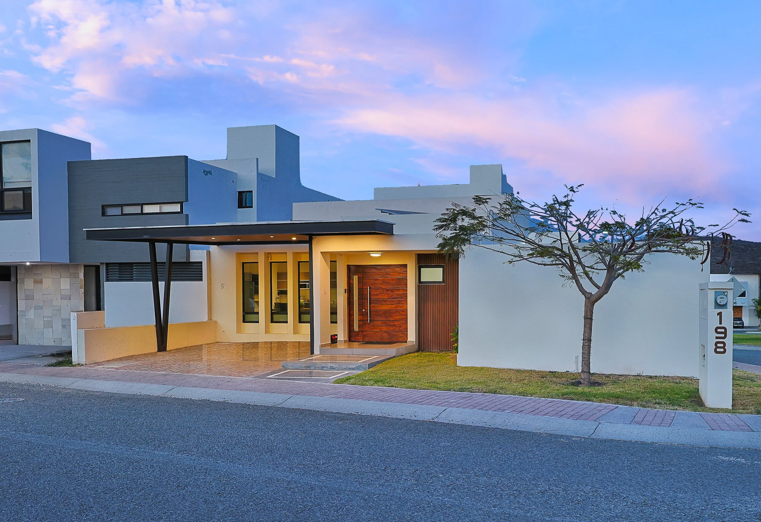 Fotografía crepuscular de arquitectura residencial contemporánea en Querétaro destacando fachada con iluminación natural y arquitectura moderna.