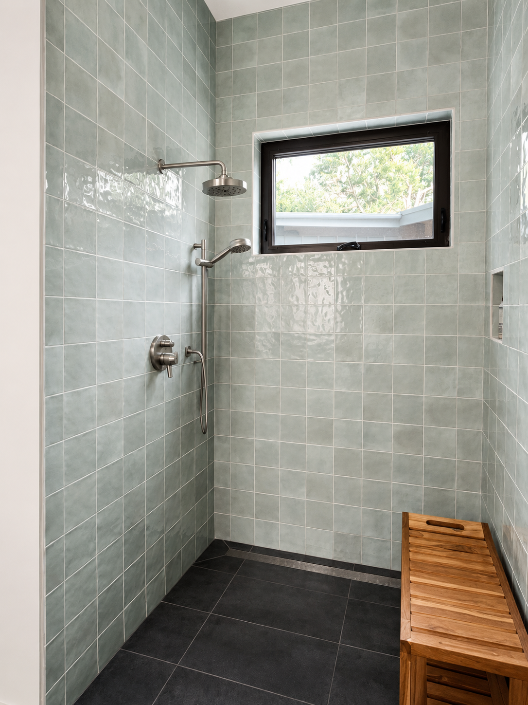 Primary bathroom with pale green tile walls, charcoal porcelain floor tiles, and brushed nickel fixtures.
