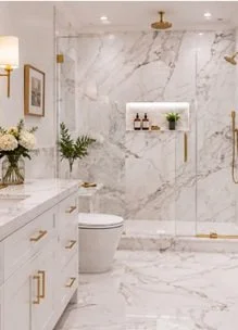 Bathroom with marble tile, white fixtures and brushed brass accents.