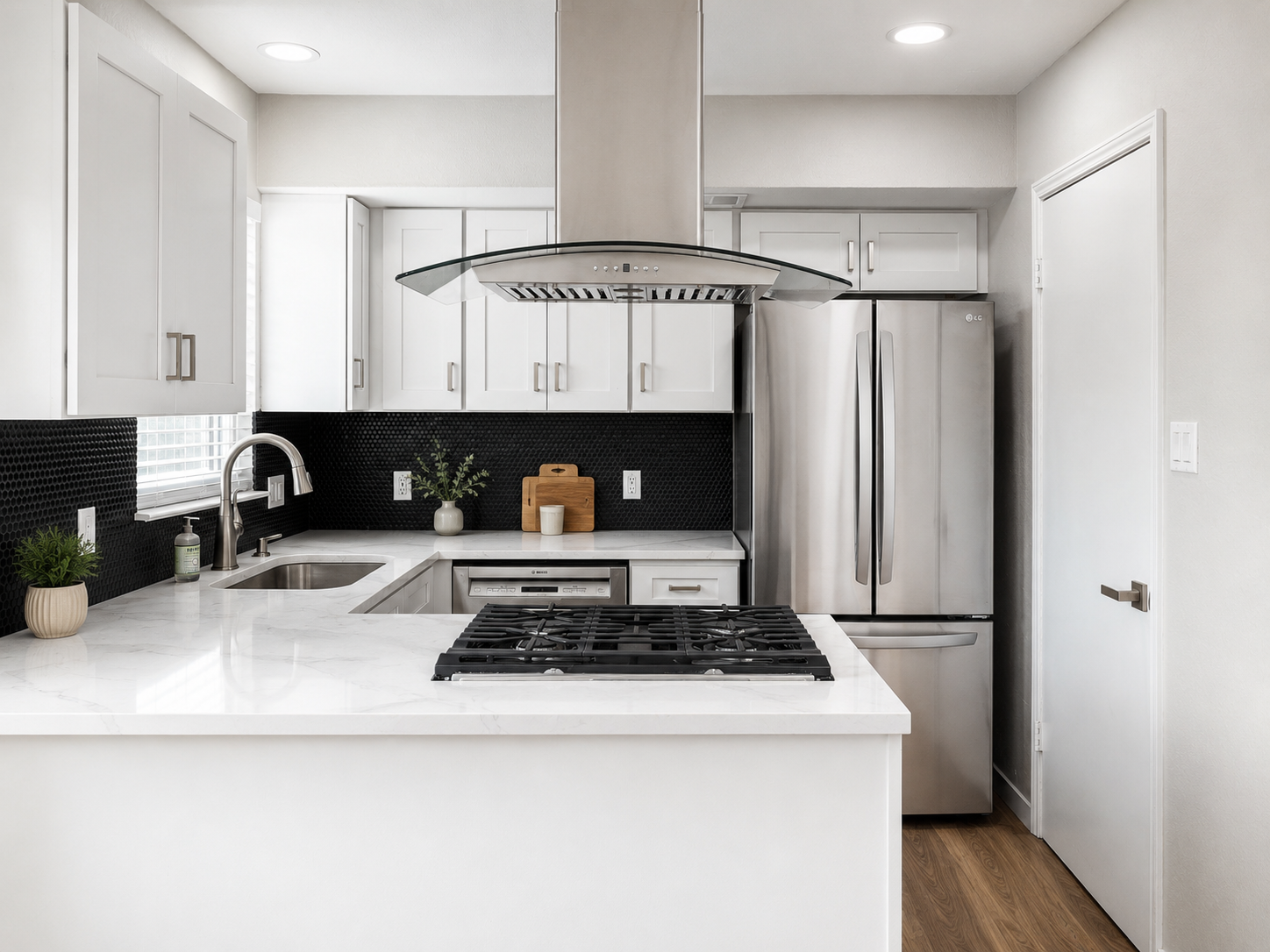 Towhhome kitchen with white cabinetry, matte black tile backsplash with black grout, white quartz countertop, and stainless steel appliances.