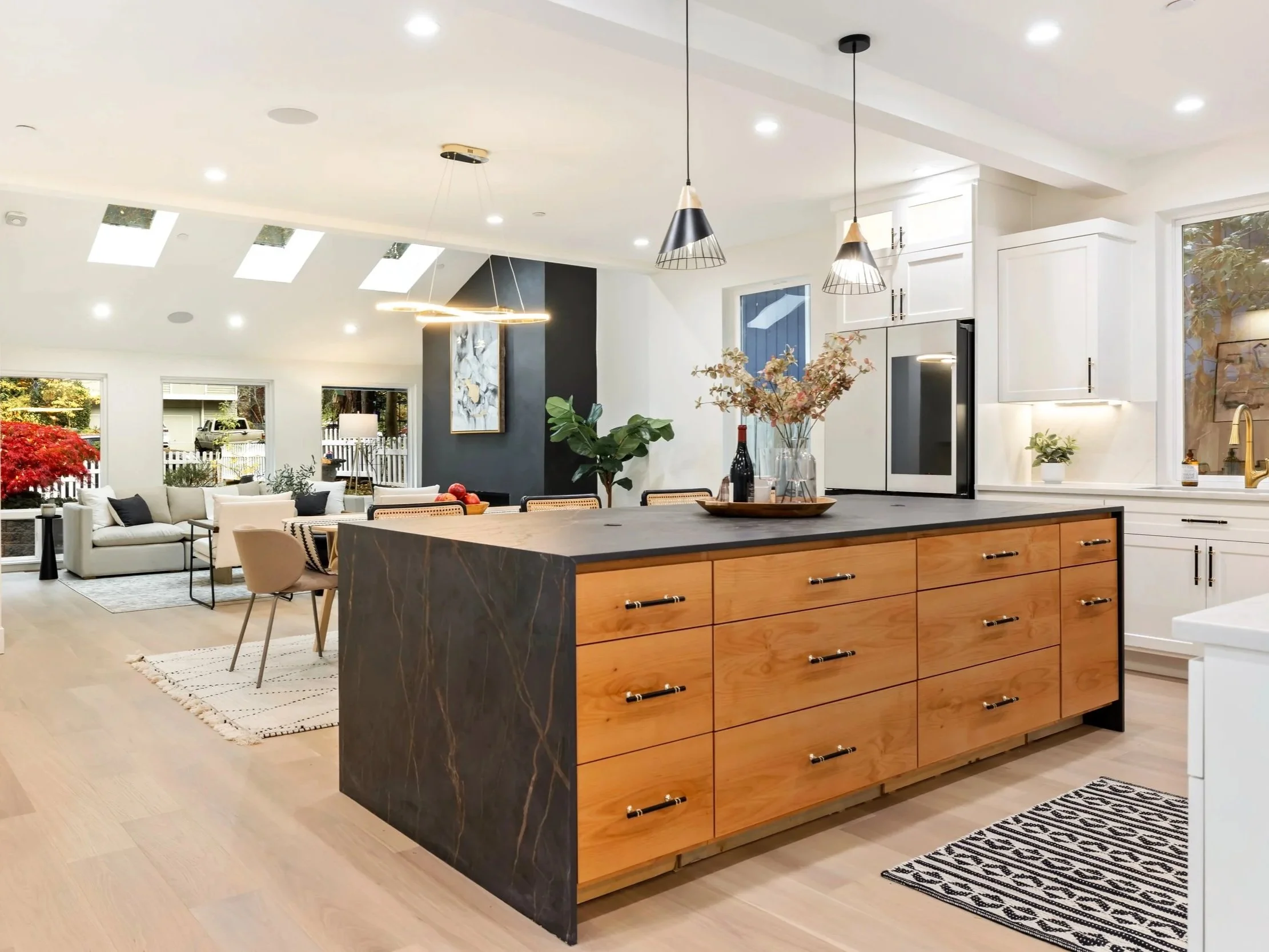Kitchen and famly room with statement island, wood tones, and brass and marble hardware.