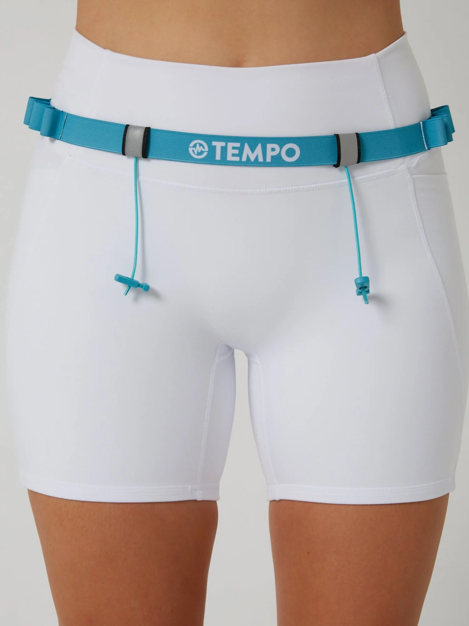 Runner wearing the PACE / TIDE blue race belt with race bib and energy gels secured for race day running.