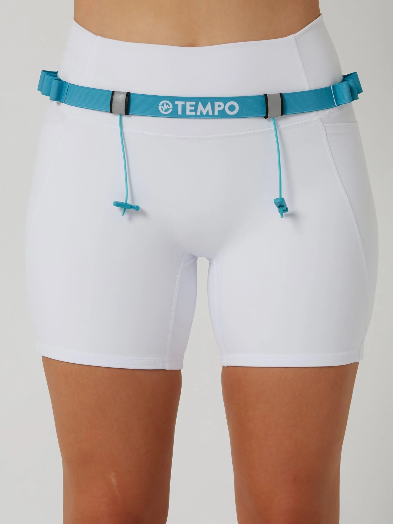 Runner wearing the PACE / TIDE blue race belt with race bib and energy gels secured for race day running.