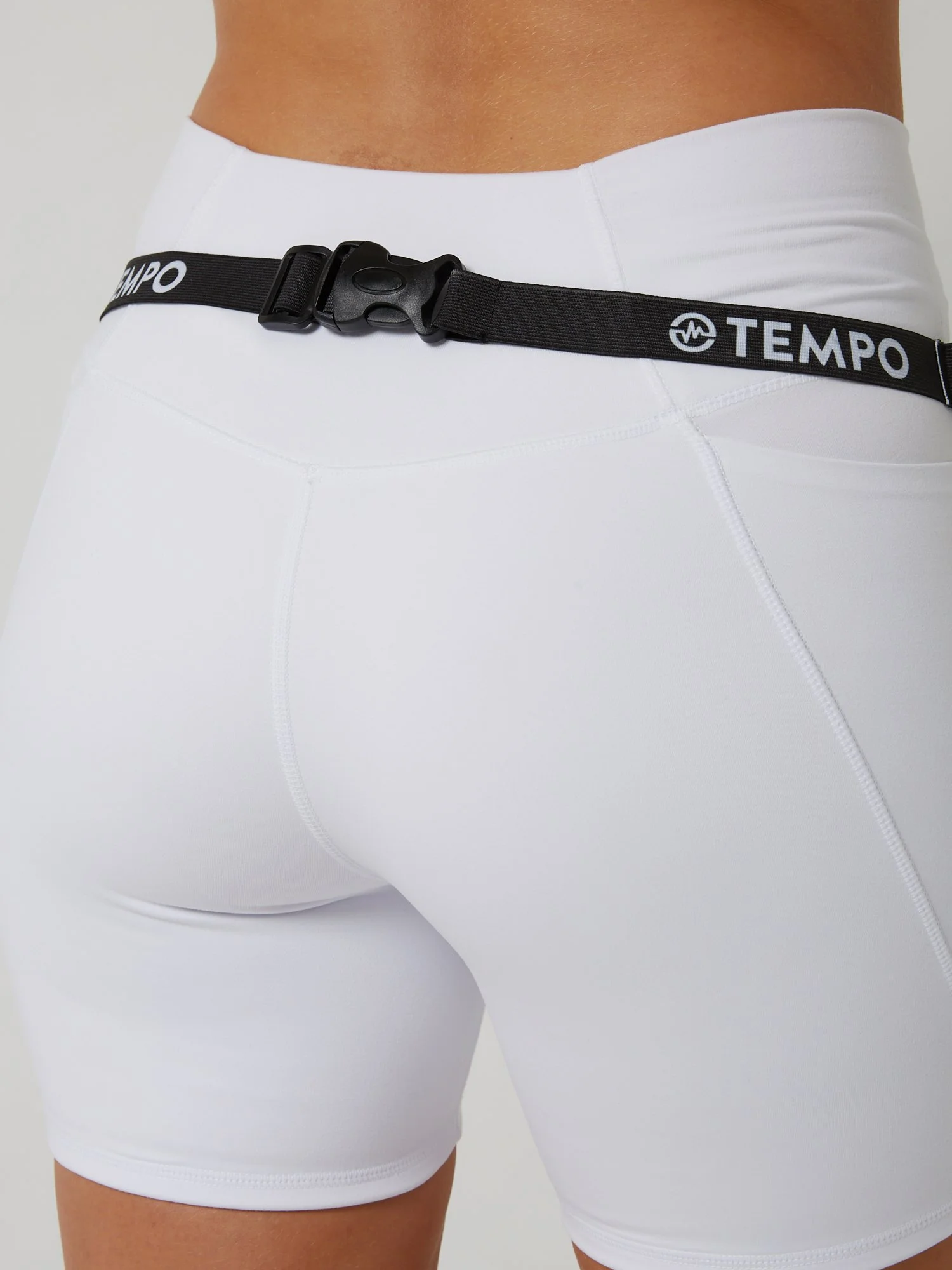 Runner wearing the PACE / ONYX black race belt with race bib and energy gels secured for race day running.