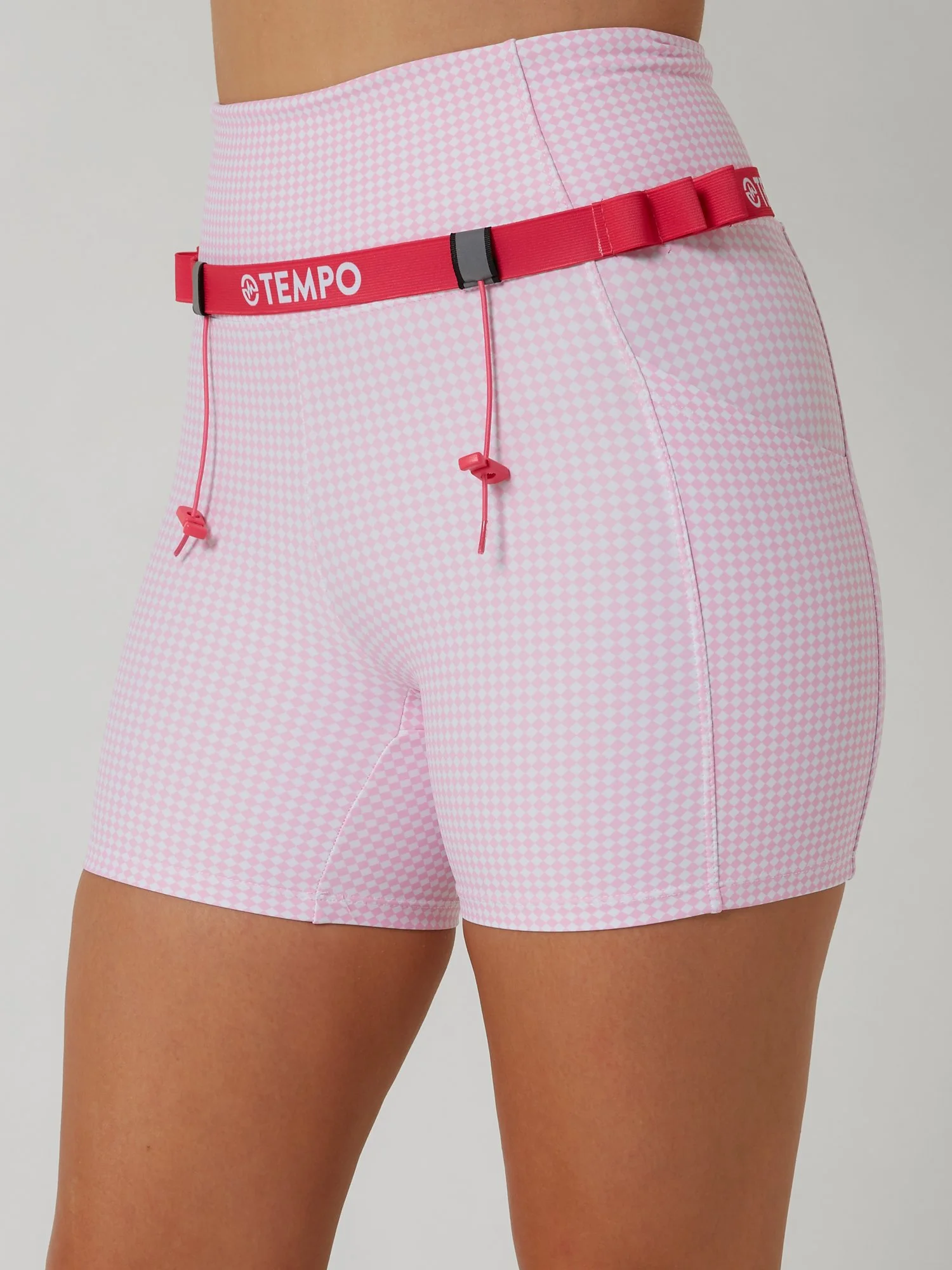 Runner wearing the PACE / ROSE pink race belt with race bib and energy gels secured for race day running.