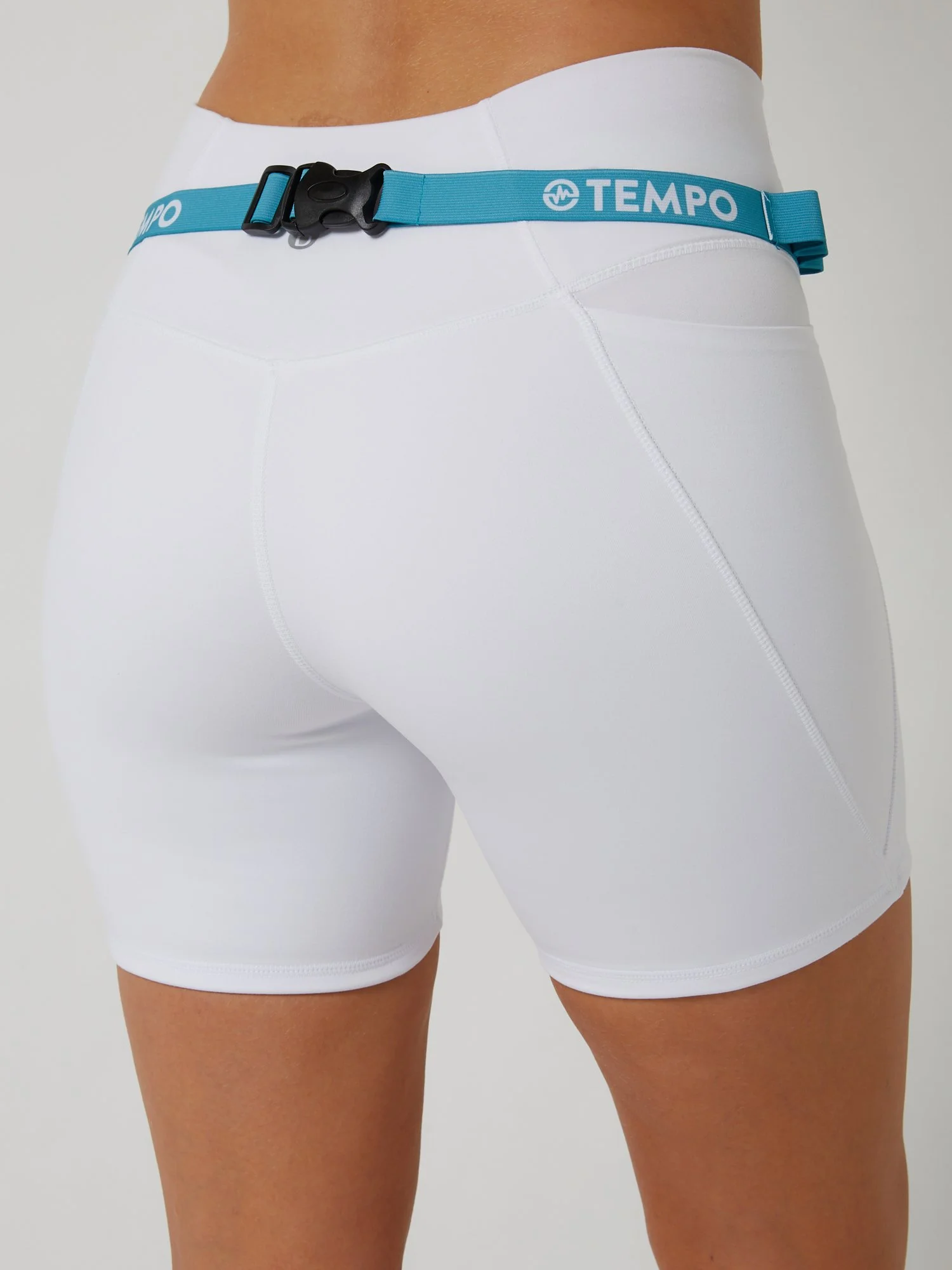 Runner wearing the PACE / TIDE blue race belt with race bib and energy gels secured for race day running.