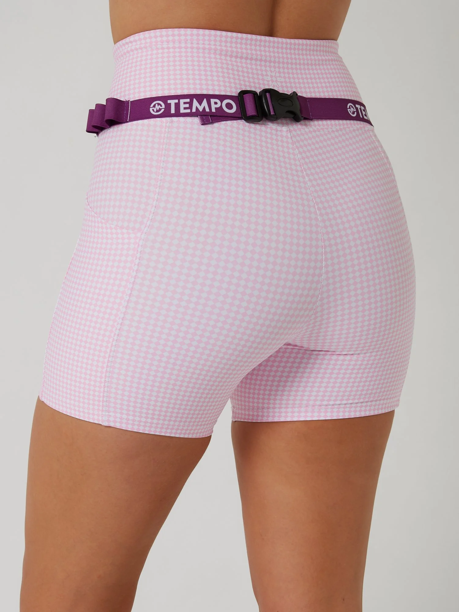 Runner wearing the PACE / VIOLET purple race belt with race bib and energy gels secured for race day running.