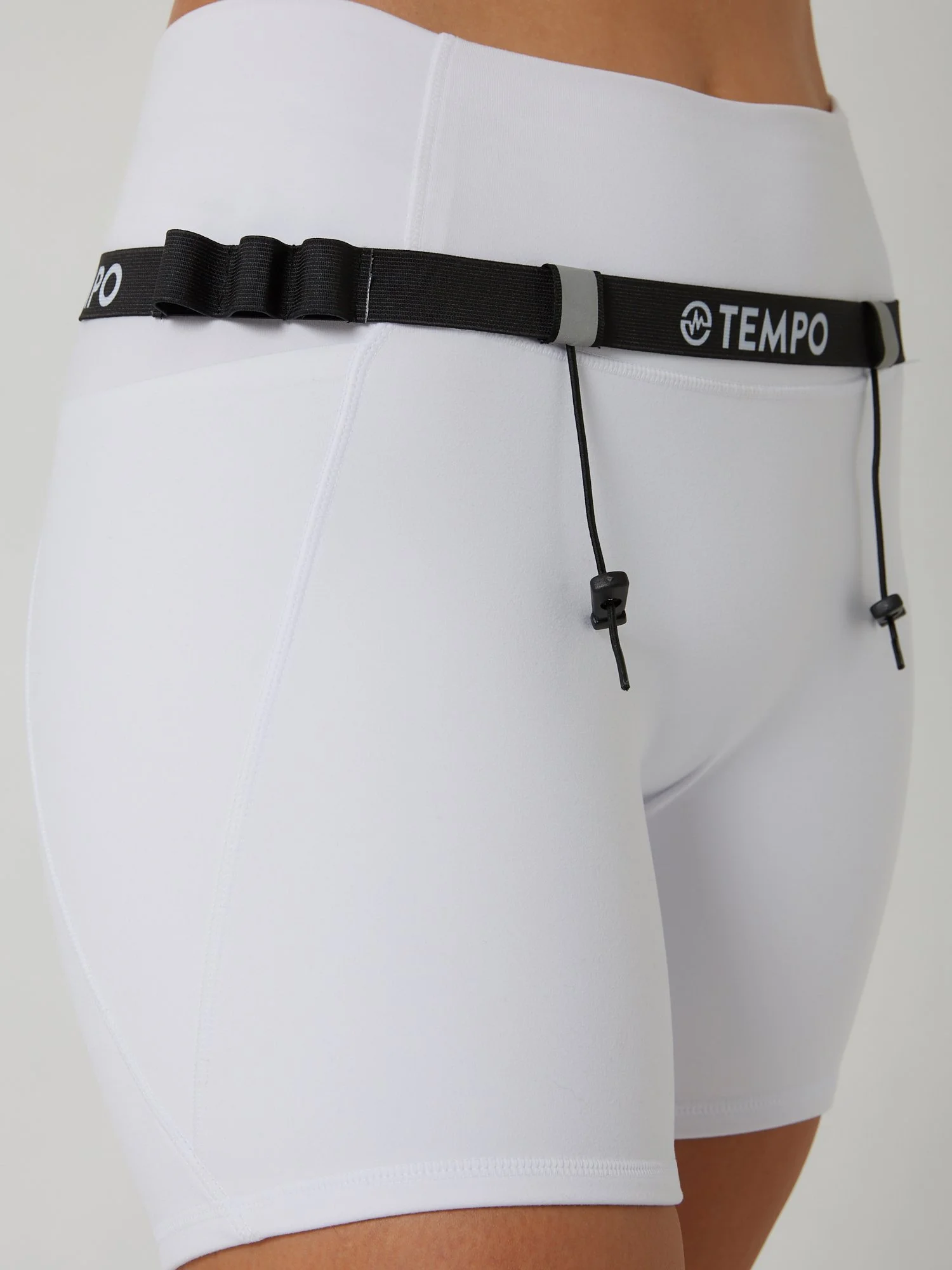 Runner wearing the PACE / ONYX black race belt with race bib and energy gels secured for race day running.