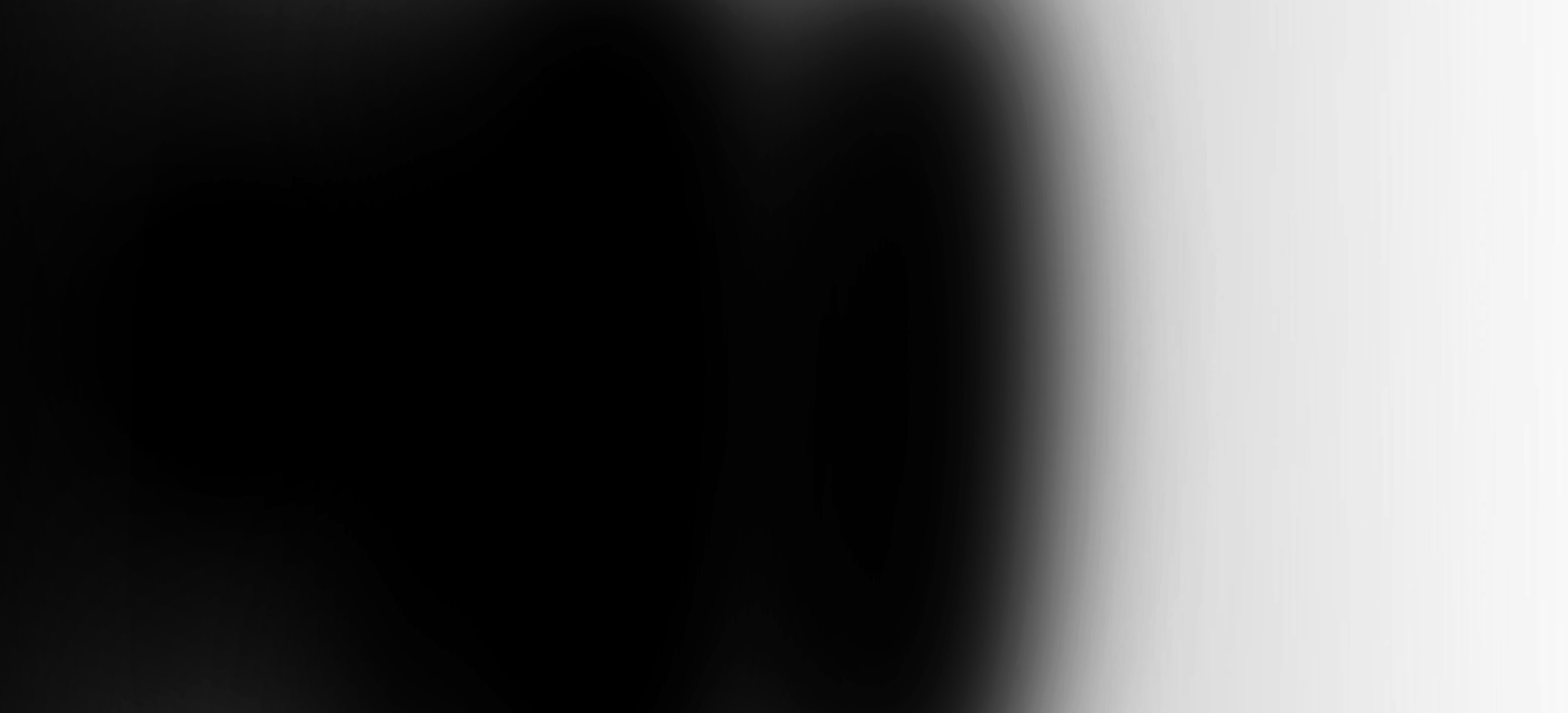 Close-up of a black cat with yellow eyes, sitting on a windowsill, looking outside.