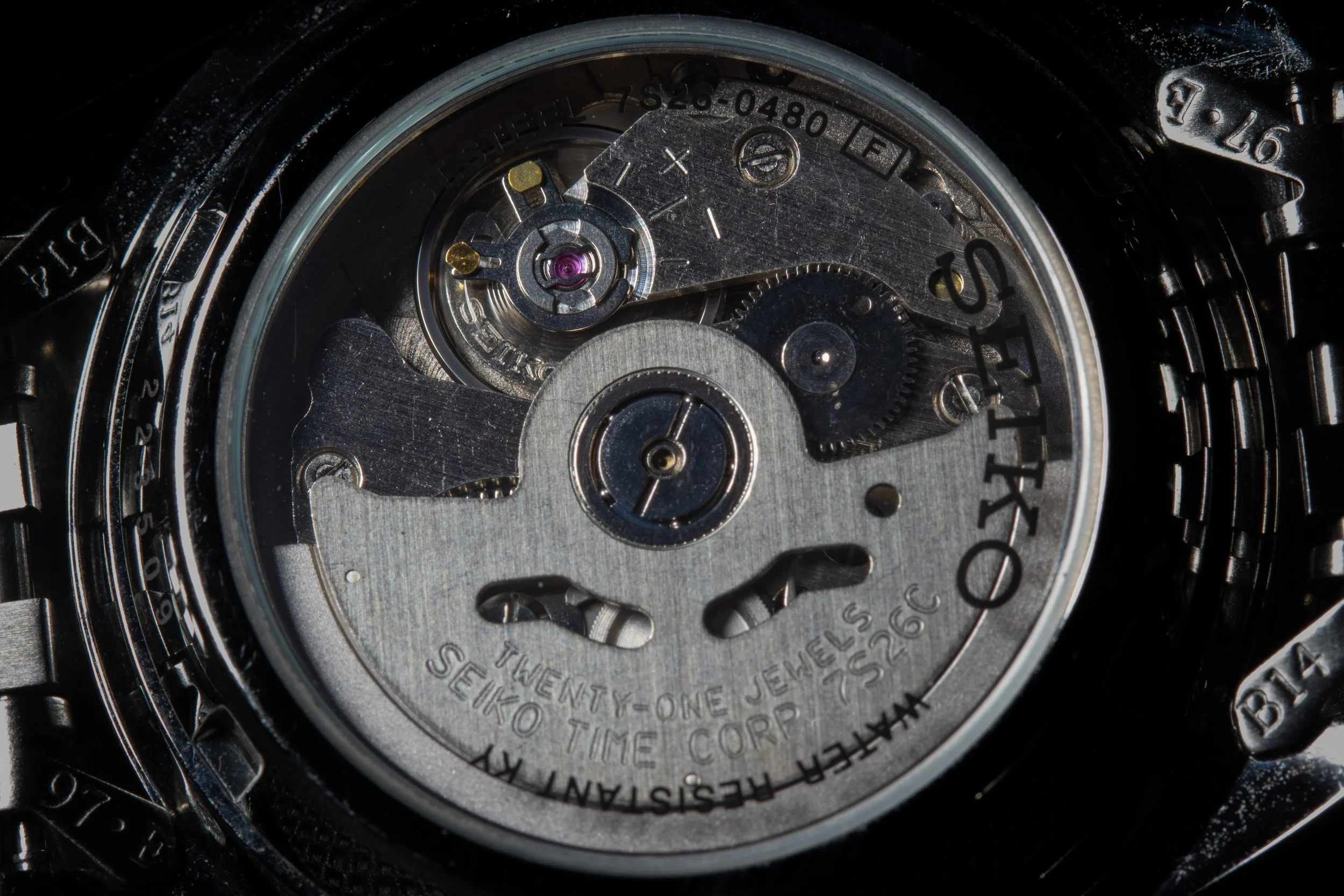 Close-up of a Seiko watch movement showing gears and mechanical components inside the watch case.