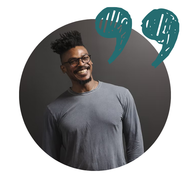 Smiling man with glasses and dreadlocks wearing a gray shirt standing in front of a dark background with a blue elephant graphic above his head.