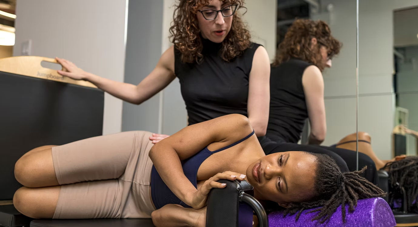 A woman lying on reformer machine for pelvic floor therapy at FlySpace Physical Therapy as the top performing arts physical therapists in New York.