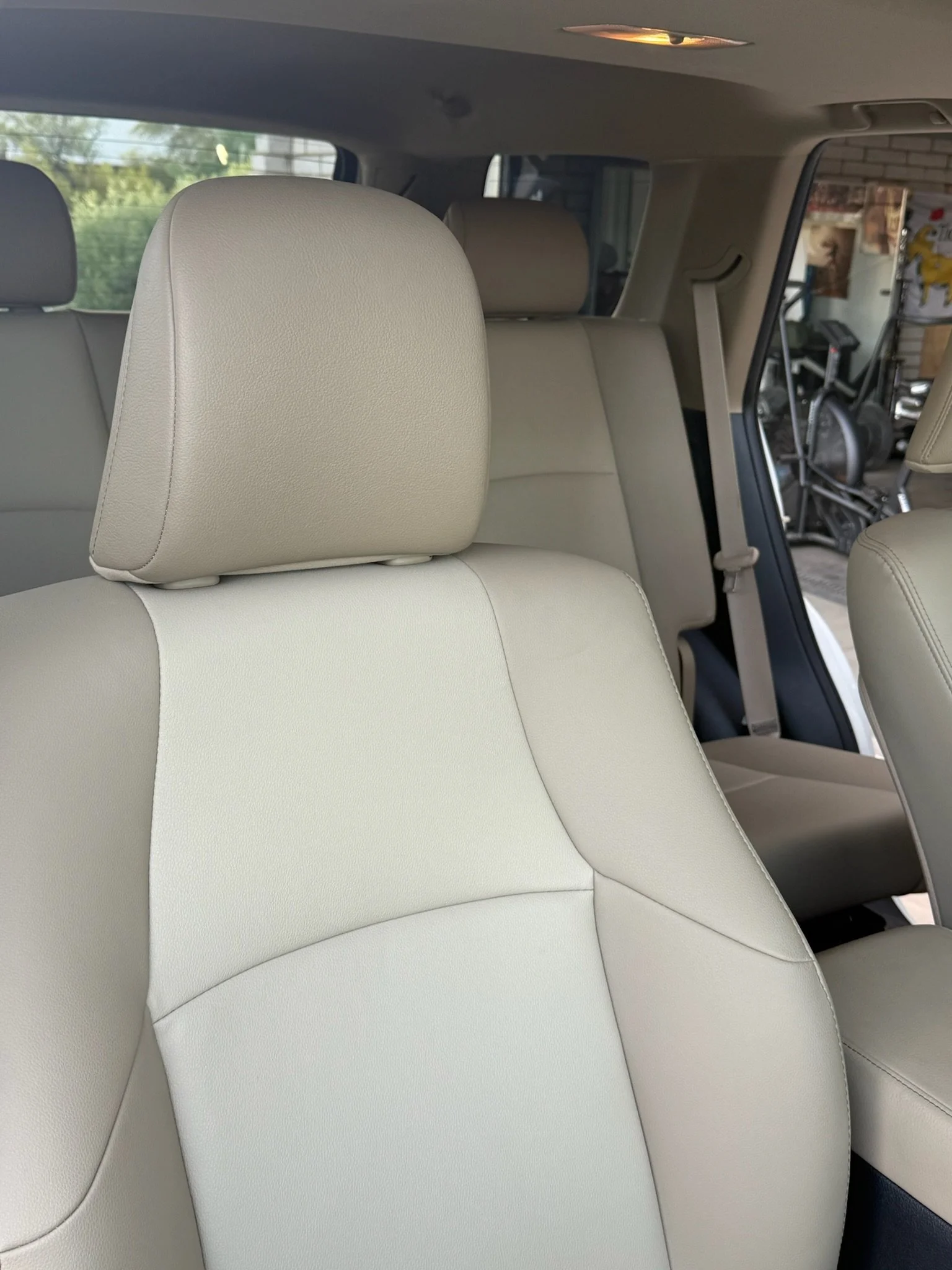 Interior of a beige car showing front and rear seats with headrests