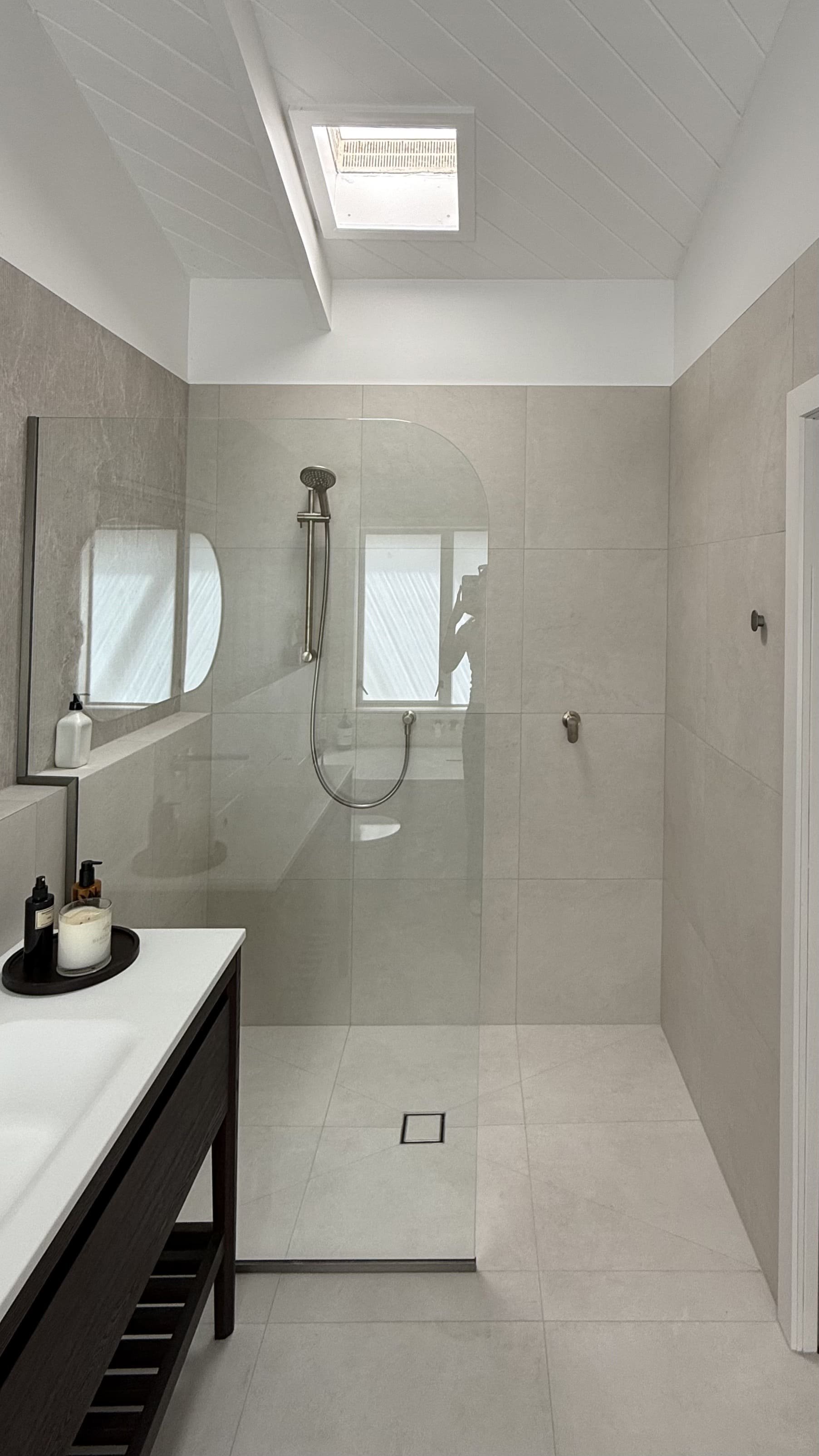 A seamless, modern walk-in shower for this bathroom renovation by Greyson Builders
