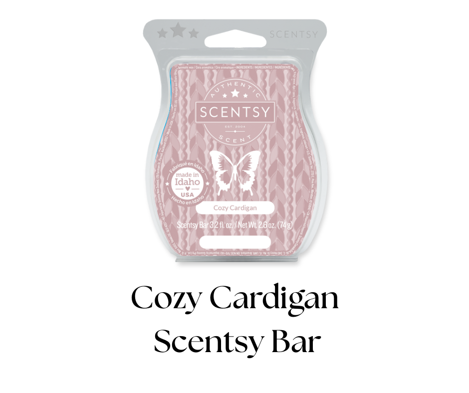 A close-up of a Scentsy Cozy Cardigan fragrance wax bar in pink and white packaging with a butterfly logo, labeled as 3.2 ounces, made in Idaho, USA.
