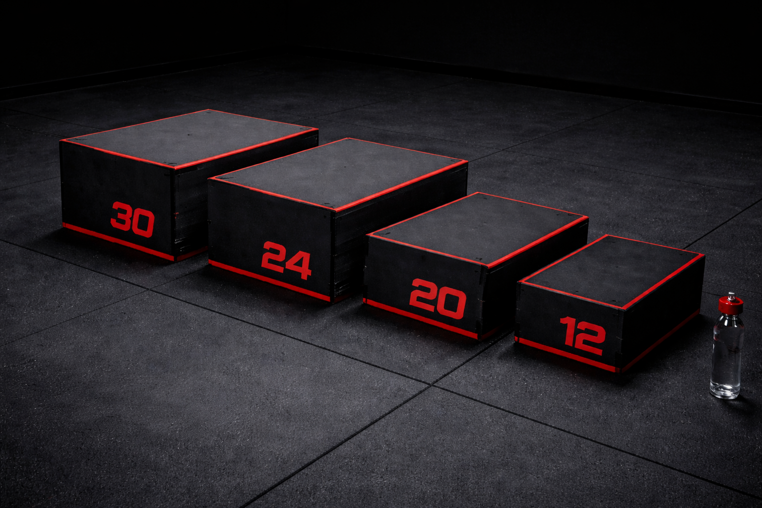 Four black plyometric boxes with red numbering and borders, arranged in ascending height from right to left, with a clear water bottle on the floor