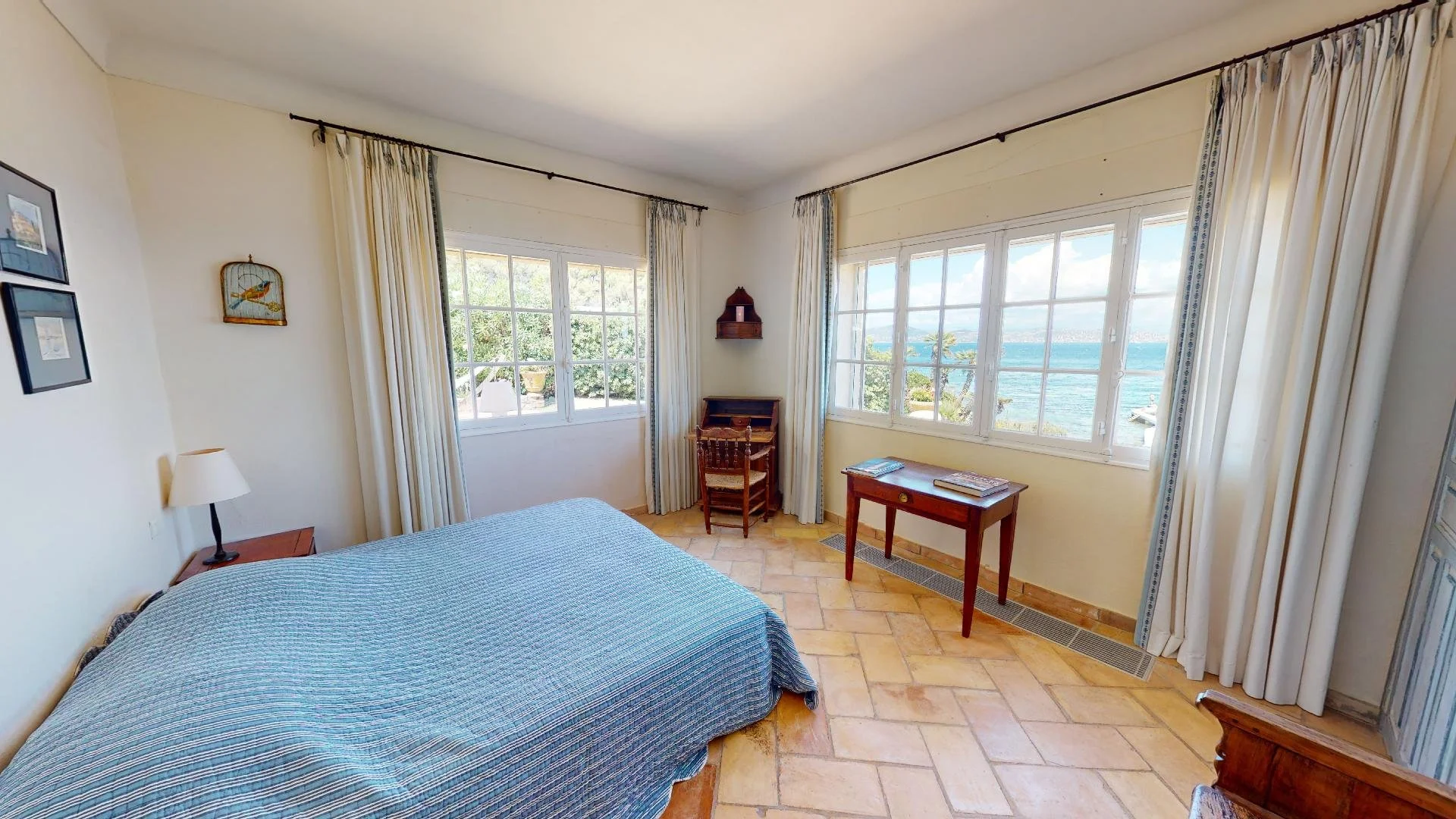 Bedroom with desk and sea view at waterfront villa in Saint-Tropez.