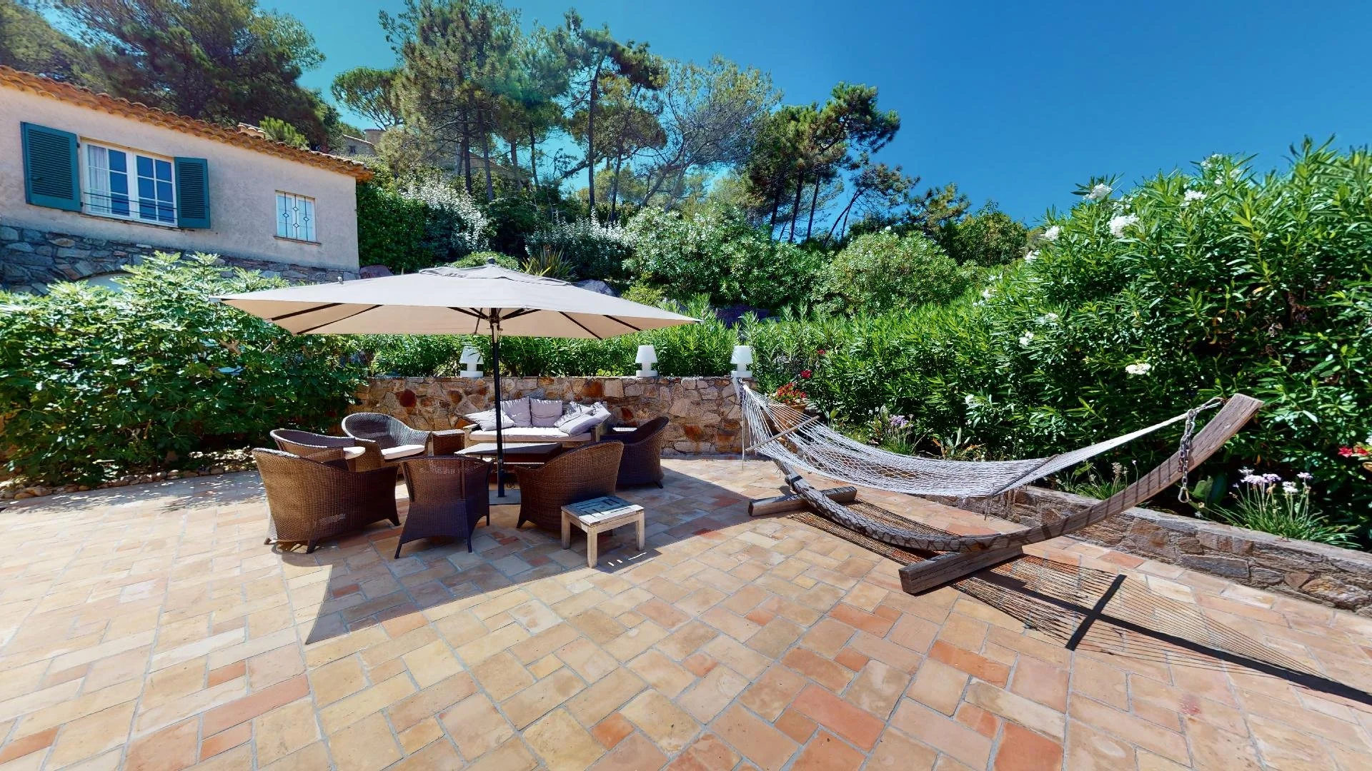 Shaded patio with hammock at family villa in Les Parcs de Saint-Tropez.