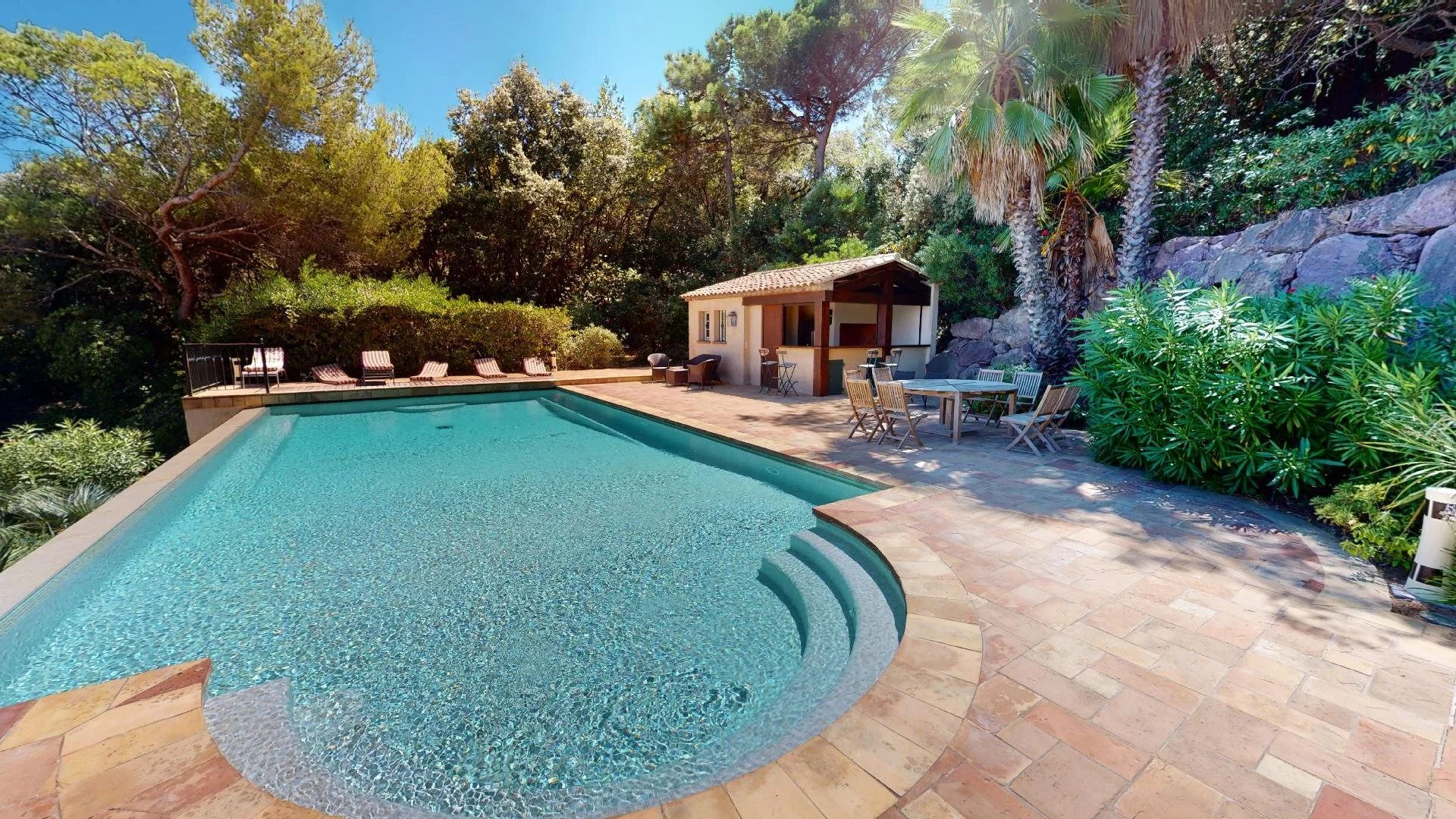 Private swimming pool surrounded by gardens at Les Parcs de Saint-Tropez villa.