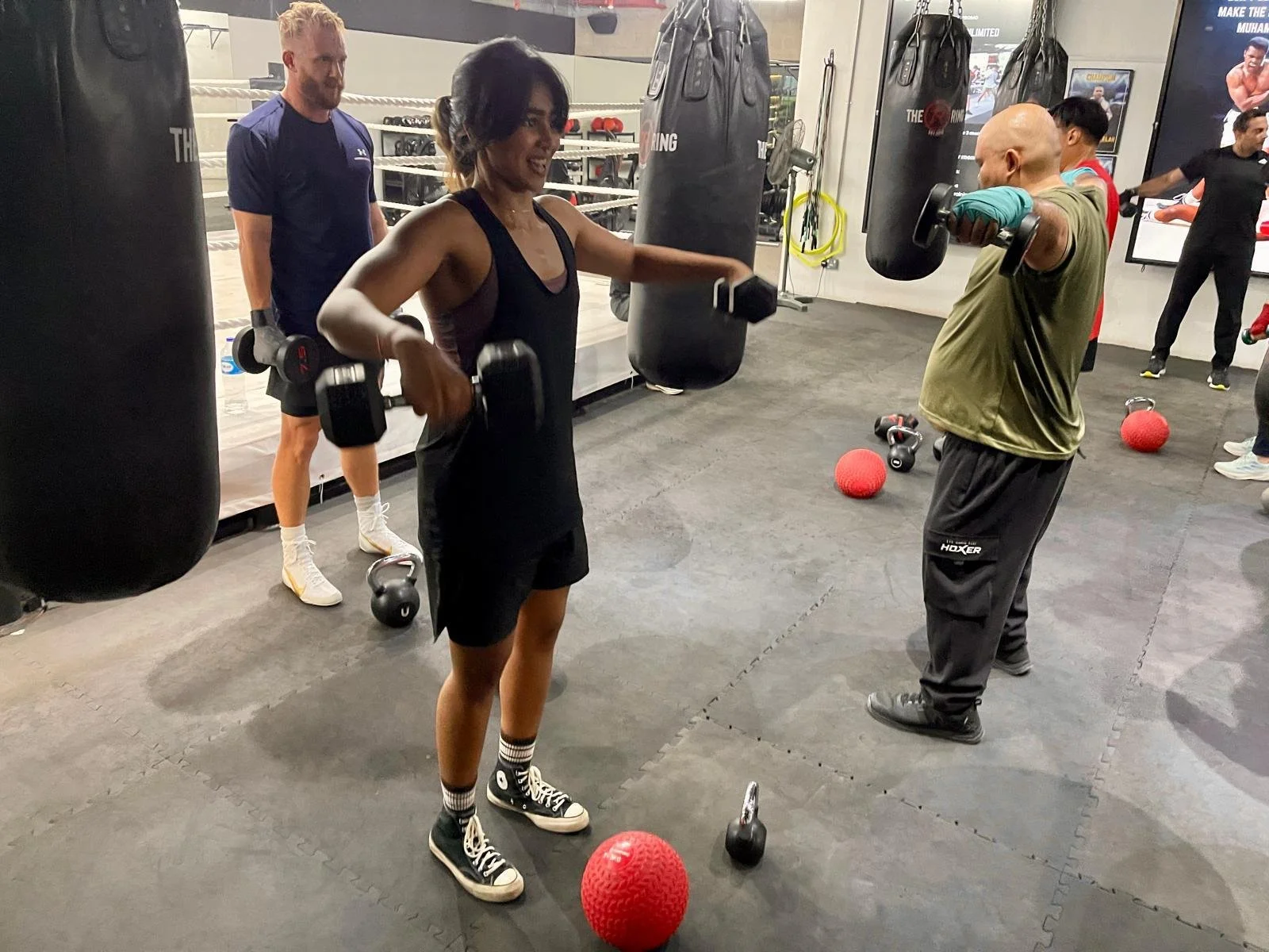 Coach Qaila leading strength and conditioning training at a boxing gym in Singapore.