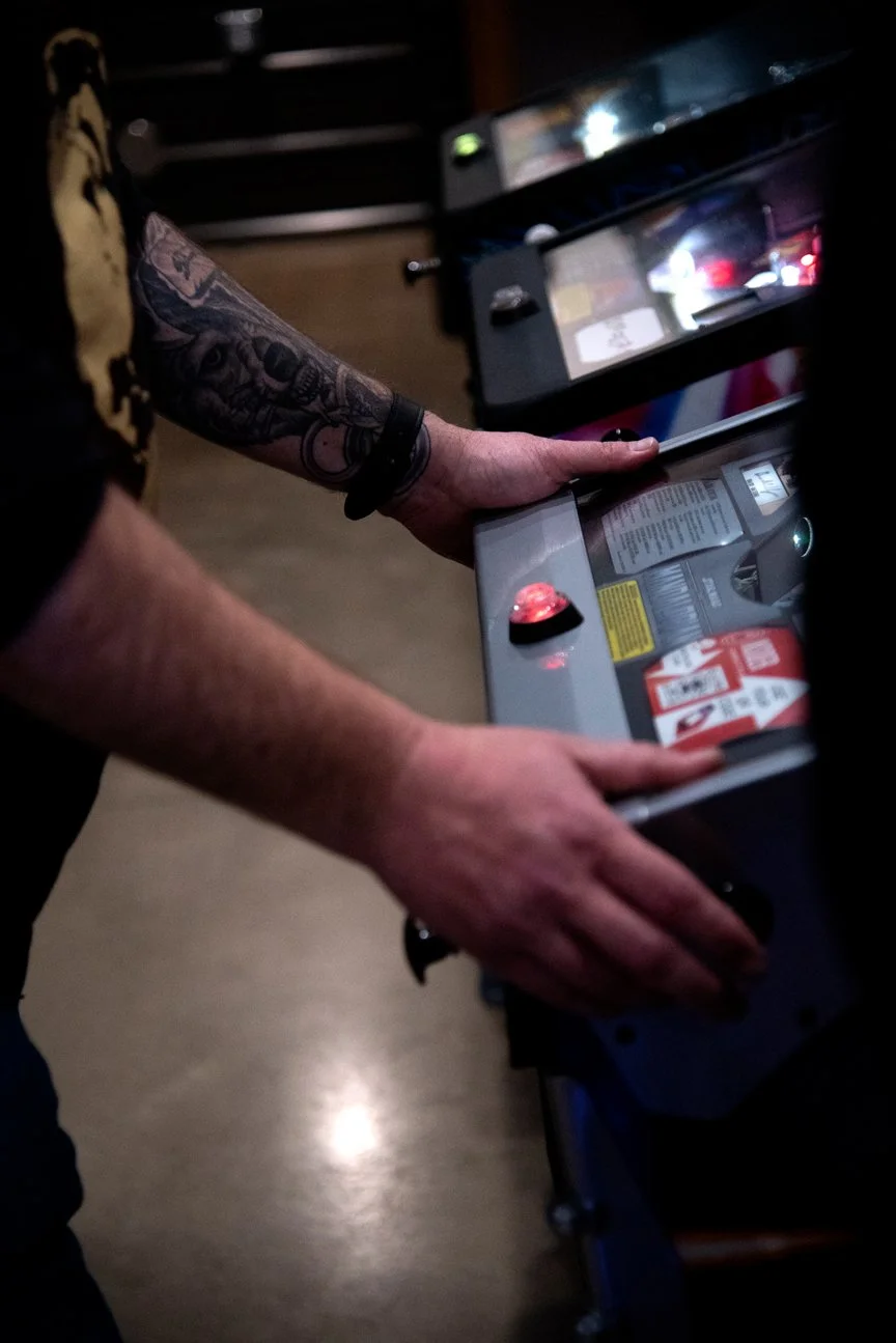 Trafford, Pennsylvania, 2025. Justin Ellsworth,  steelworker at USS, spending a Friday evening off at a local bar with friends, playing arcade games.