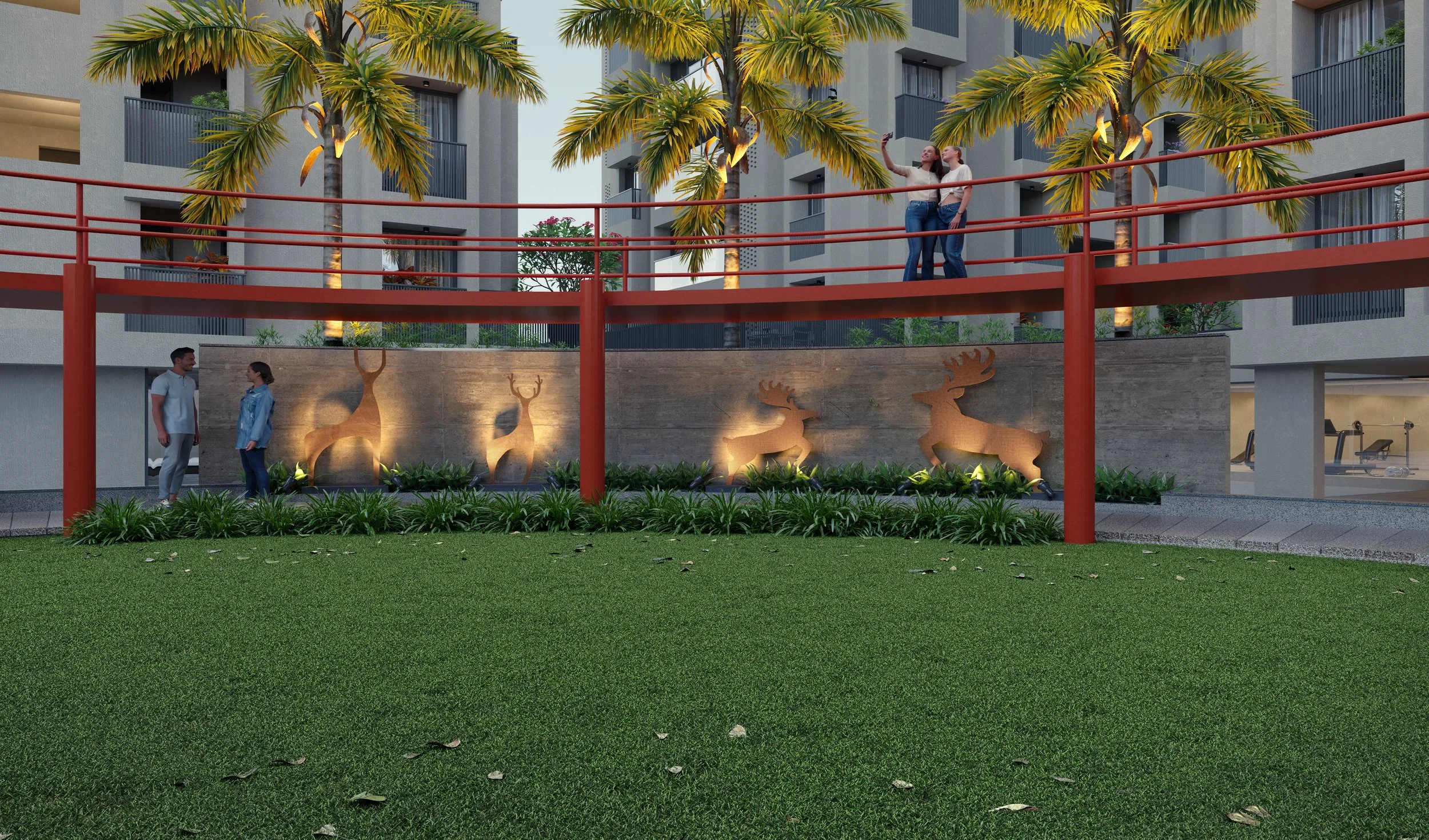 A modern apartment complex courtyard with palm trees, decorative reindeer silhouettes on a wall, and a red balcony railing. Two women are taking a selfie on the upper level, two people are talking near the wall, and the area is lit with outdoor light